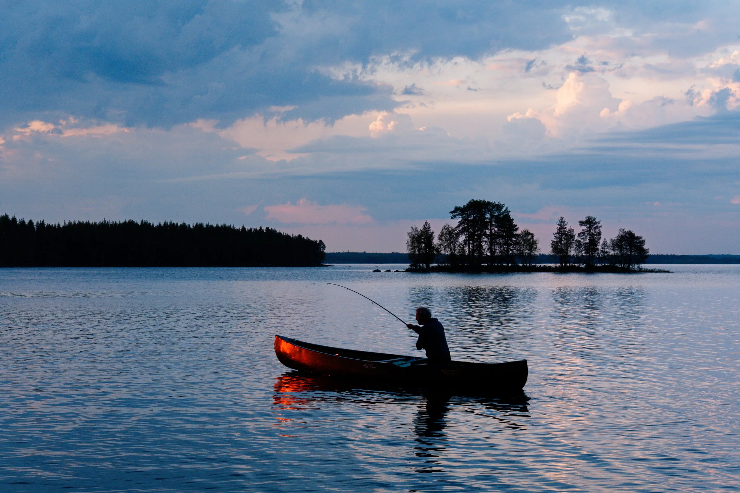 Fishing from a canoe at sunset in Finland