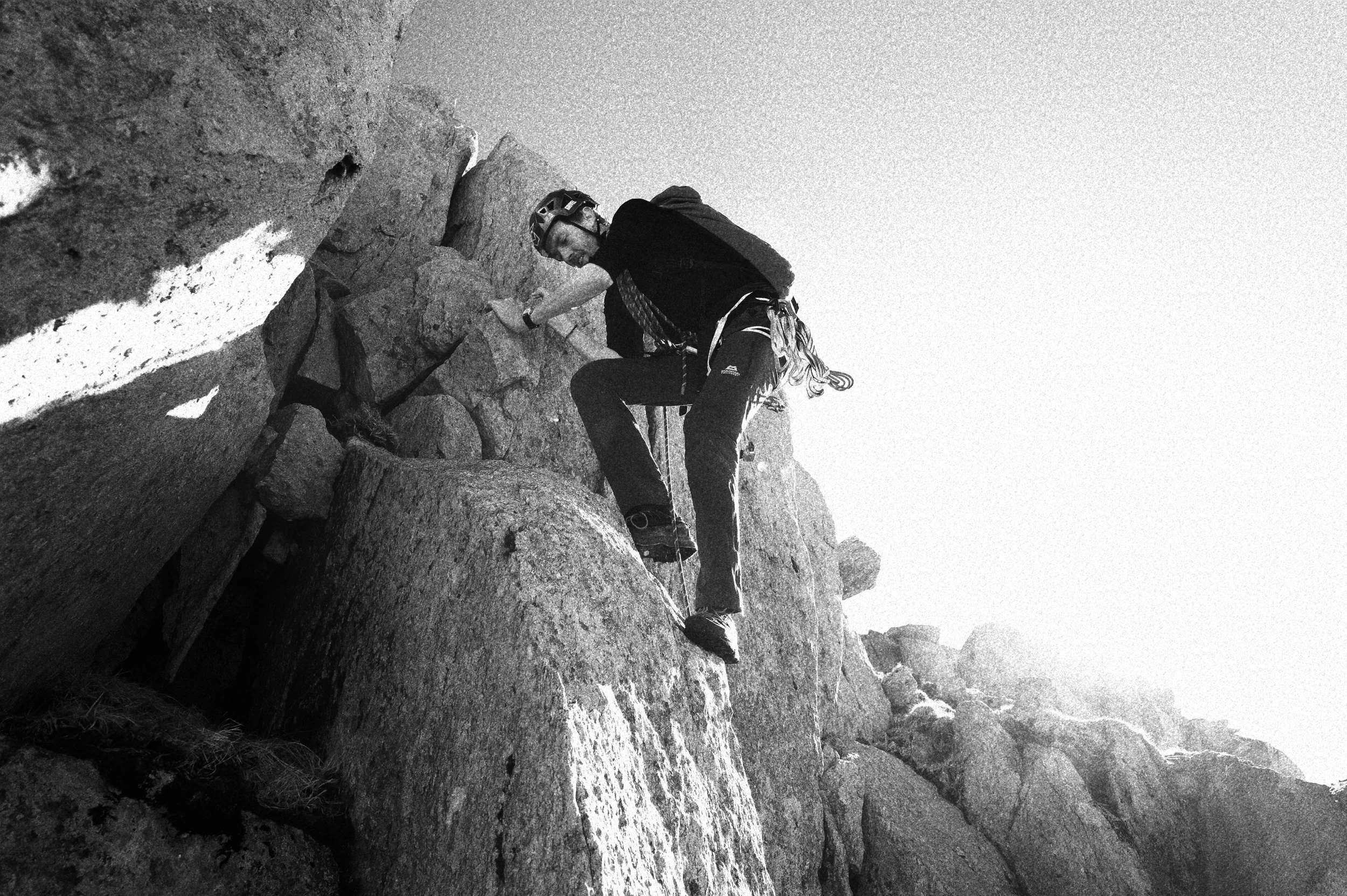 Black and white image of a mountaineer climbing in Eryri/ Snowdonia