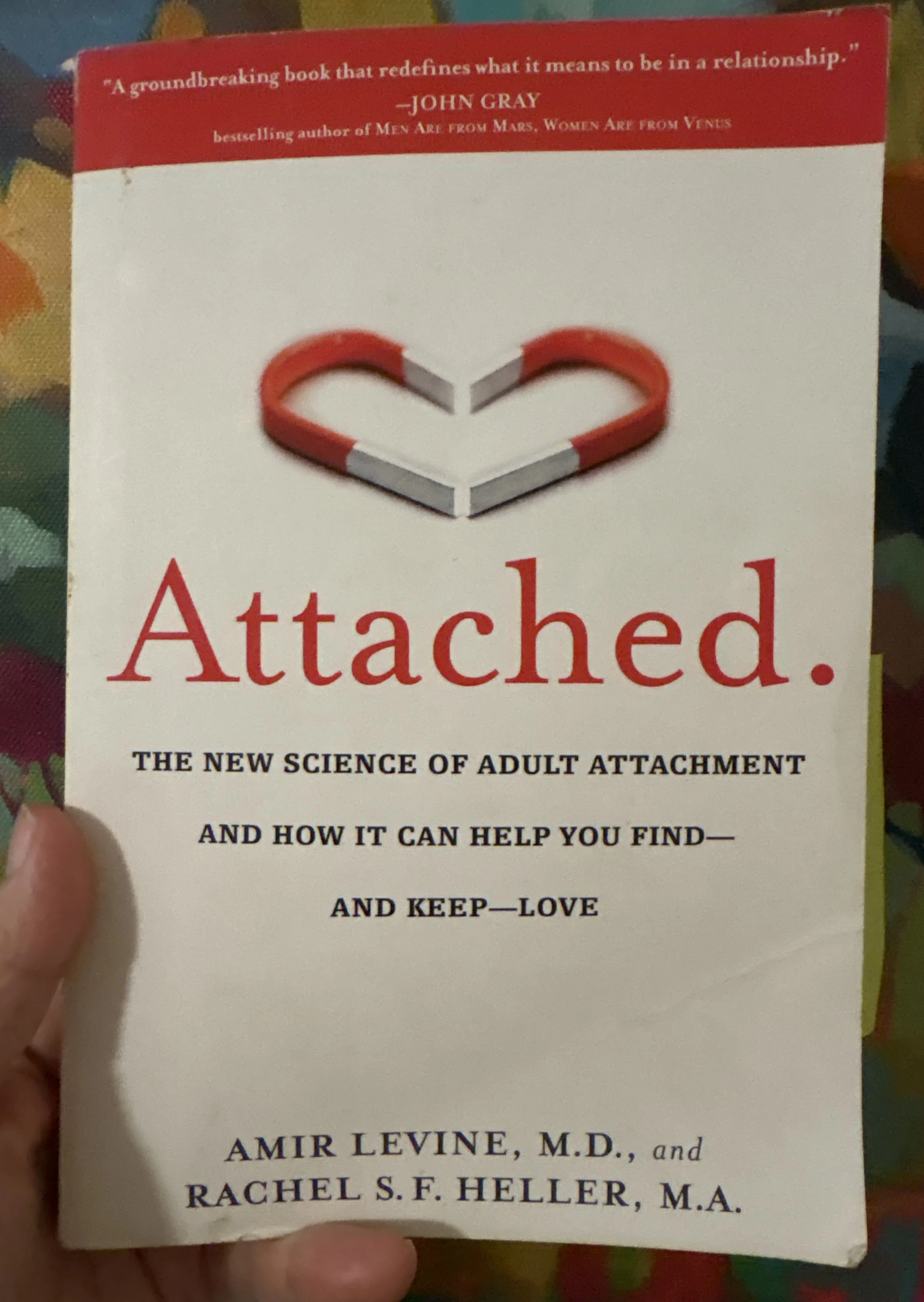 Book cover with a red and white figurative heart made of candy canes and a white heart shape inside, titled 'Attached: The New Science of Adult Attachment and How It Can Help You Find—And Keep—Love' with author names Amir Levine and Rachel S. F. Heller.