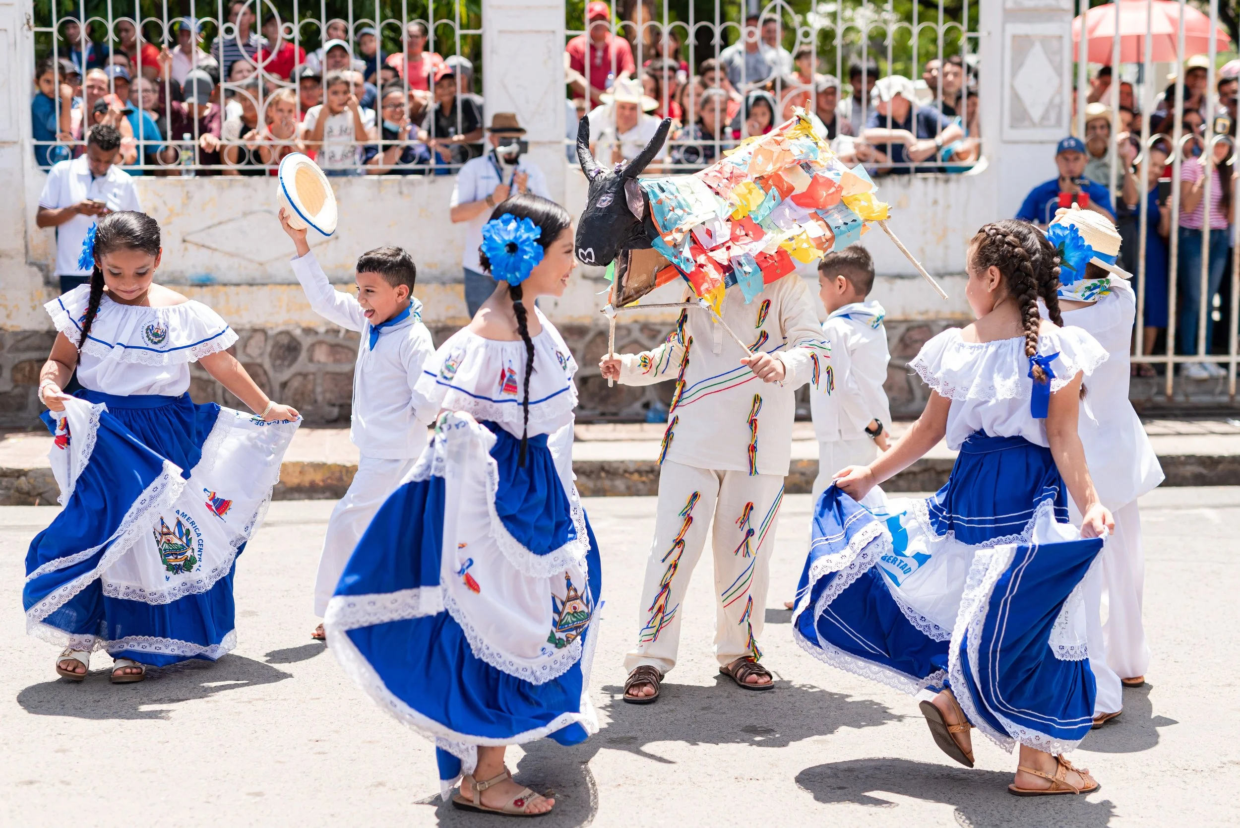 A group of children dancing in traditional El Salvadorian clothing