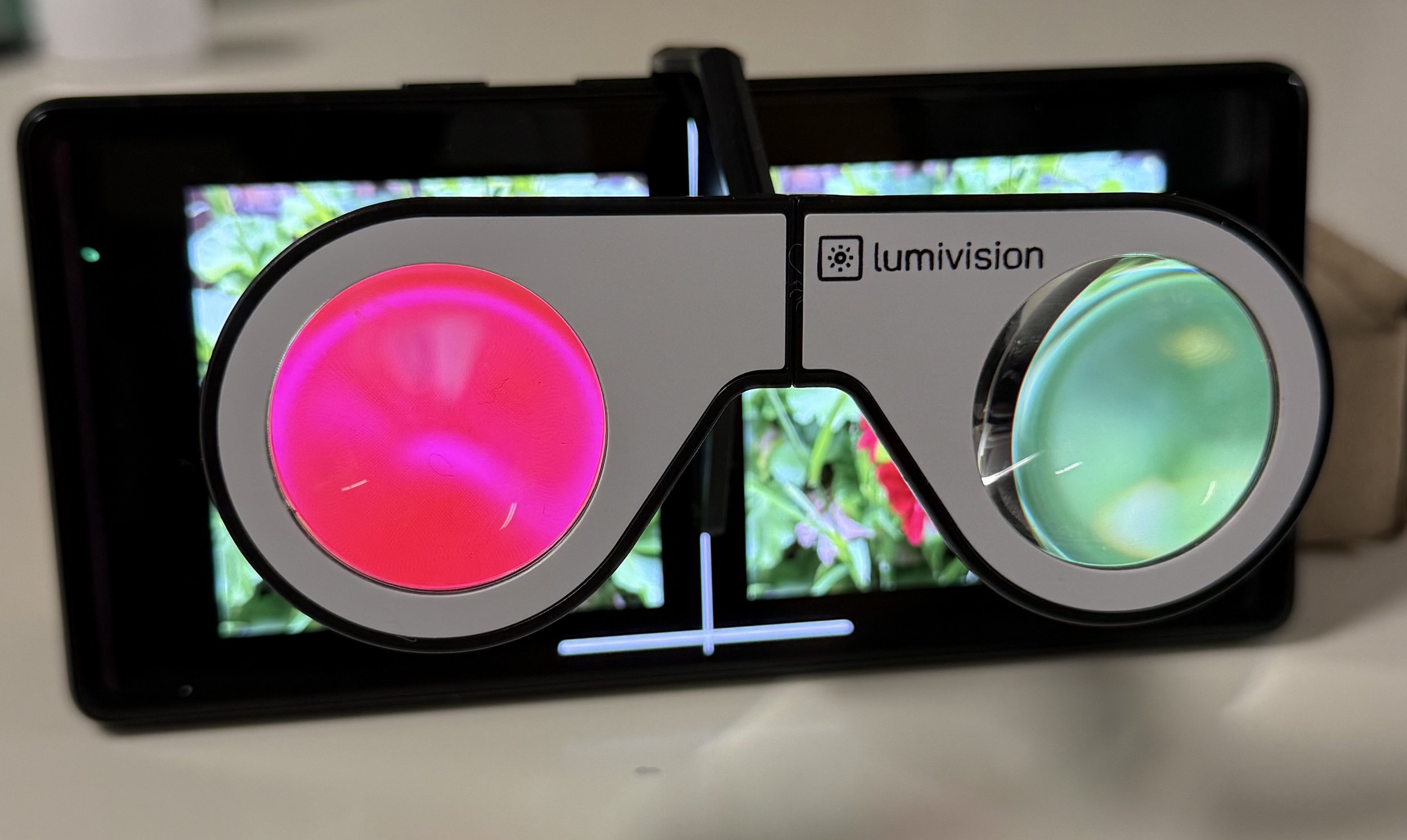 small headset connected to a smartphone illuminated by red and green floral image