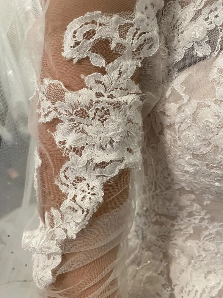 Close-up of white floral lace fabric on a wedding dress. This is a custom sleeve that I created for one of my brides.