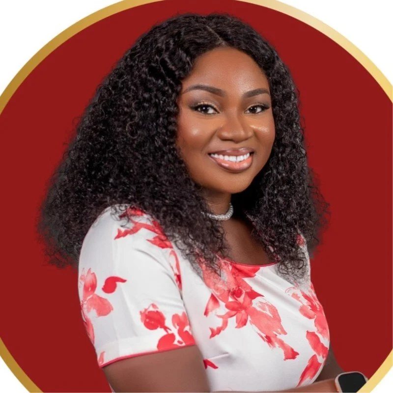 Portrait of a smiling African American woman with curly hair, wearing a white dress with red floral pattern, a pearl necklace, and a smartwatch, posed against a red and gold circular background.
