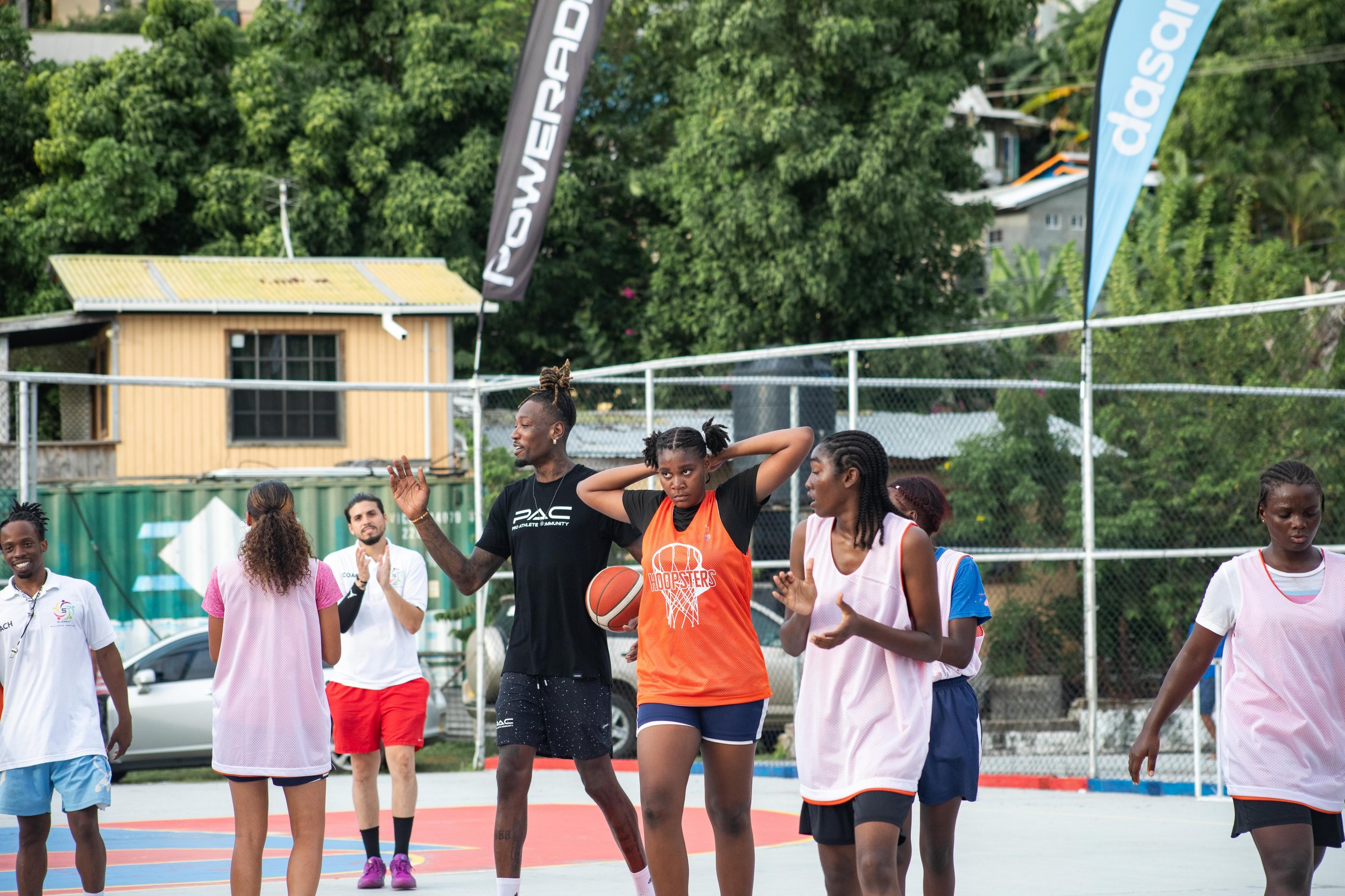 Women playing basketball on an outdoor court.