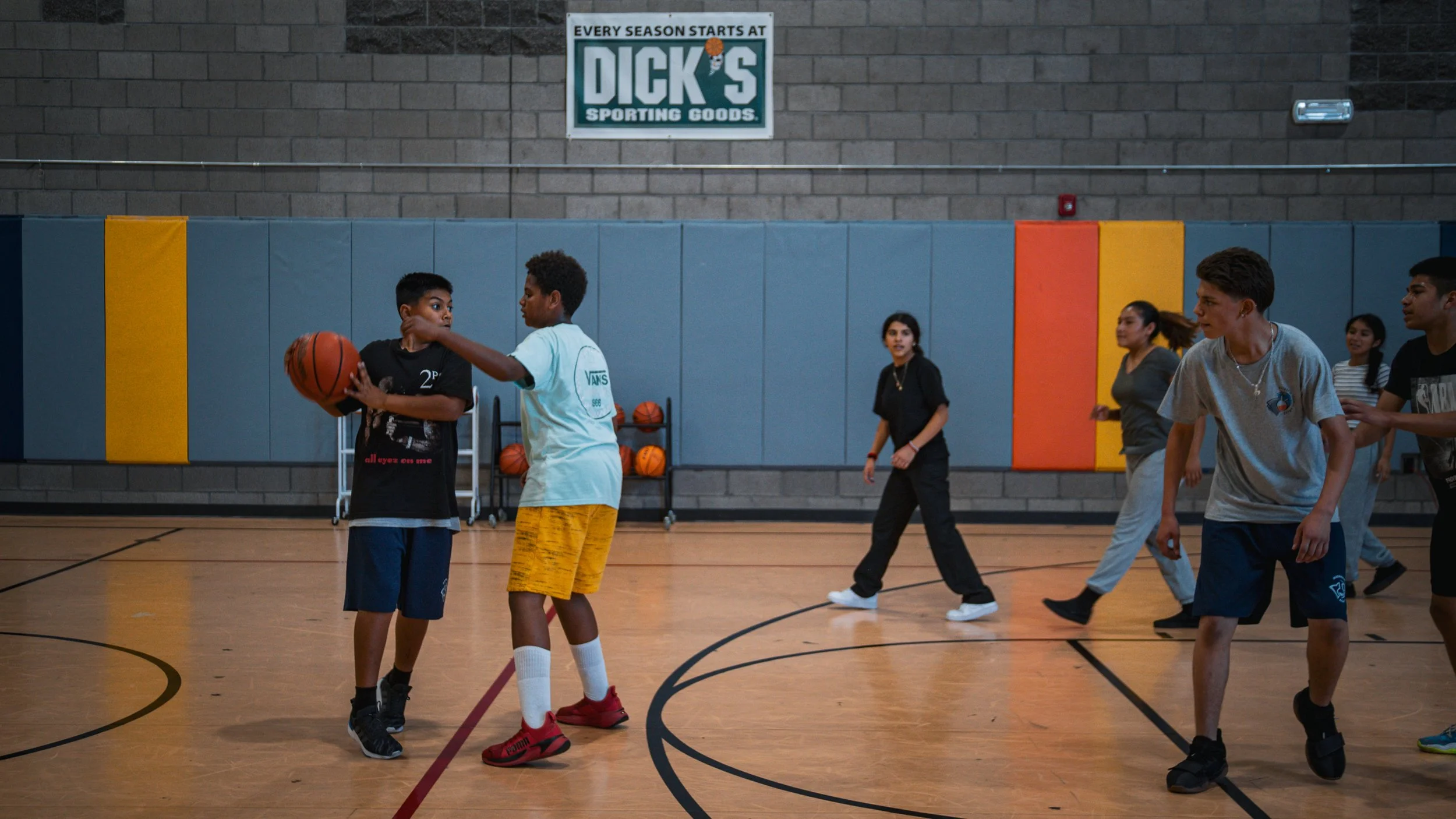 Children playing basketball in an indoor gym at Magnolia Science Academy Basketball Camp in 2023