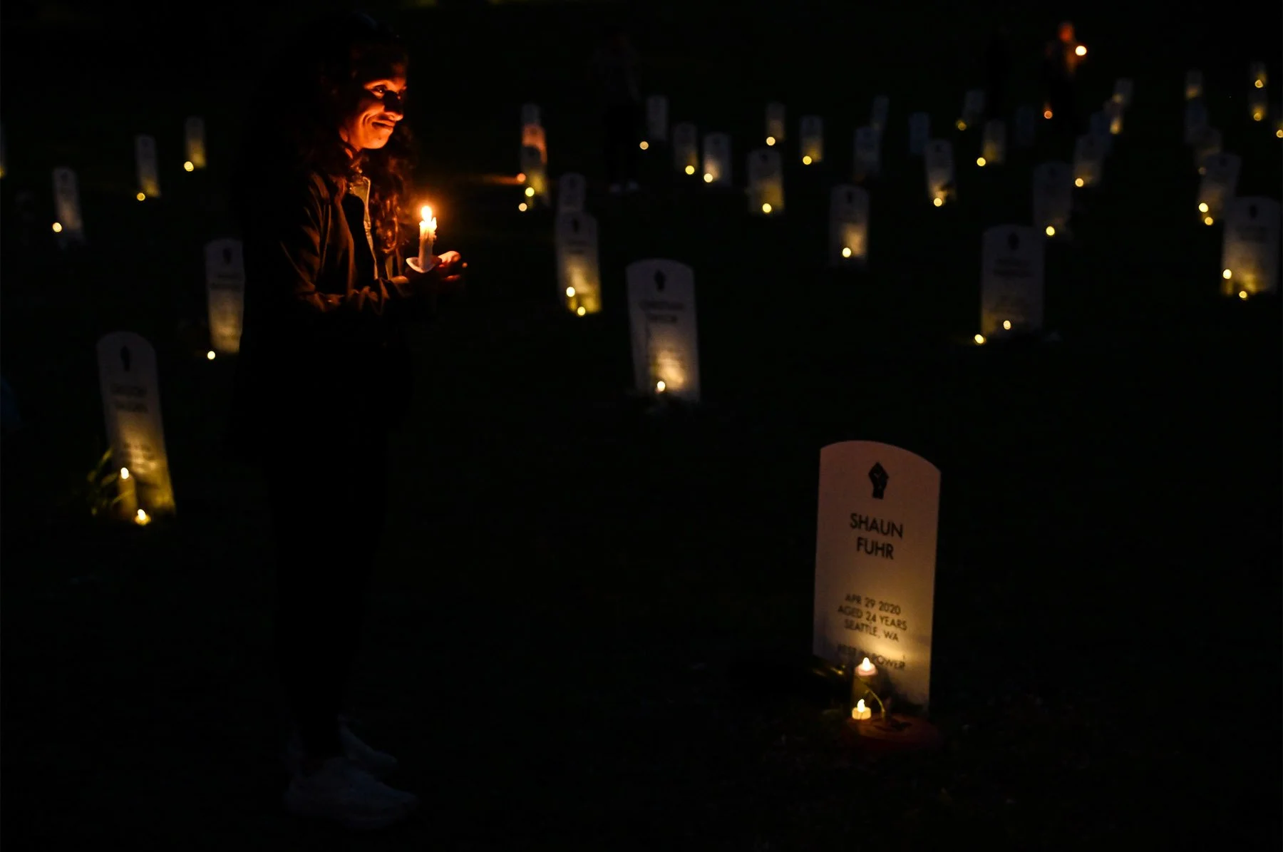 Leena Aurora carries a candle while walking through the Say Their Names art installation in Minneapolis, Minn., on the fifth anniversary of George Floyd’s death on Sunday, May 25, 2025.