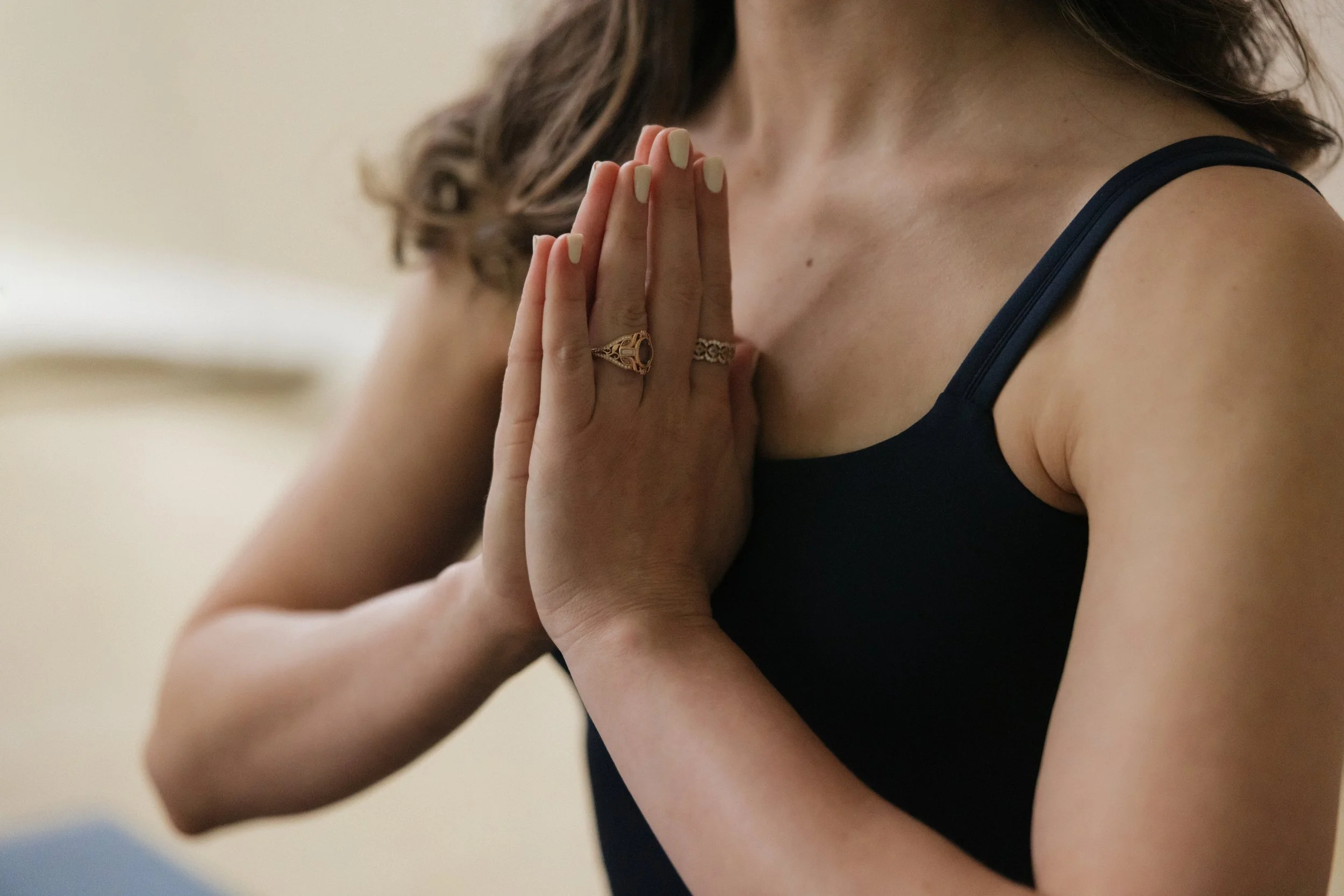 Close up of woman's hands in prayer post at her chest
