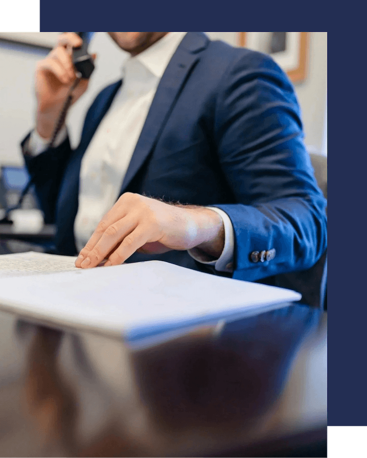 While on a phone call with a client from Cambridge, Russell Partners LLC employee reviews their tax documents.