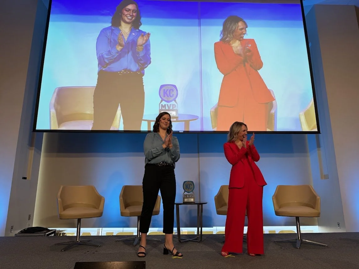 two people standing on stage clapping