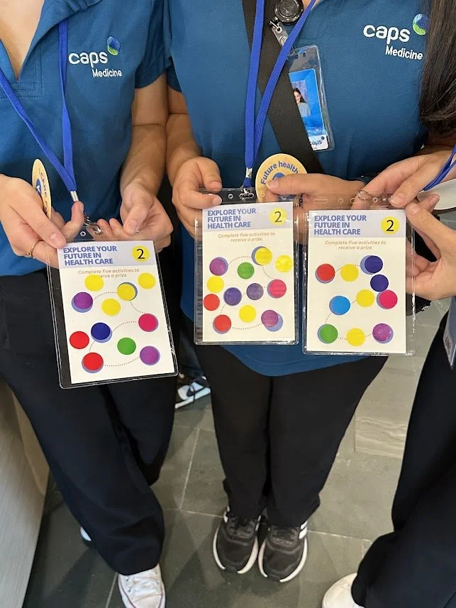 students holding lanyards with stickers on them