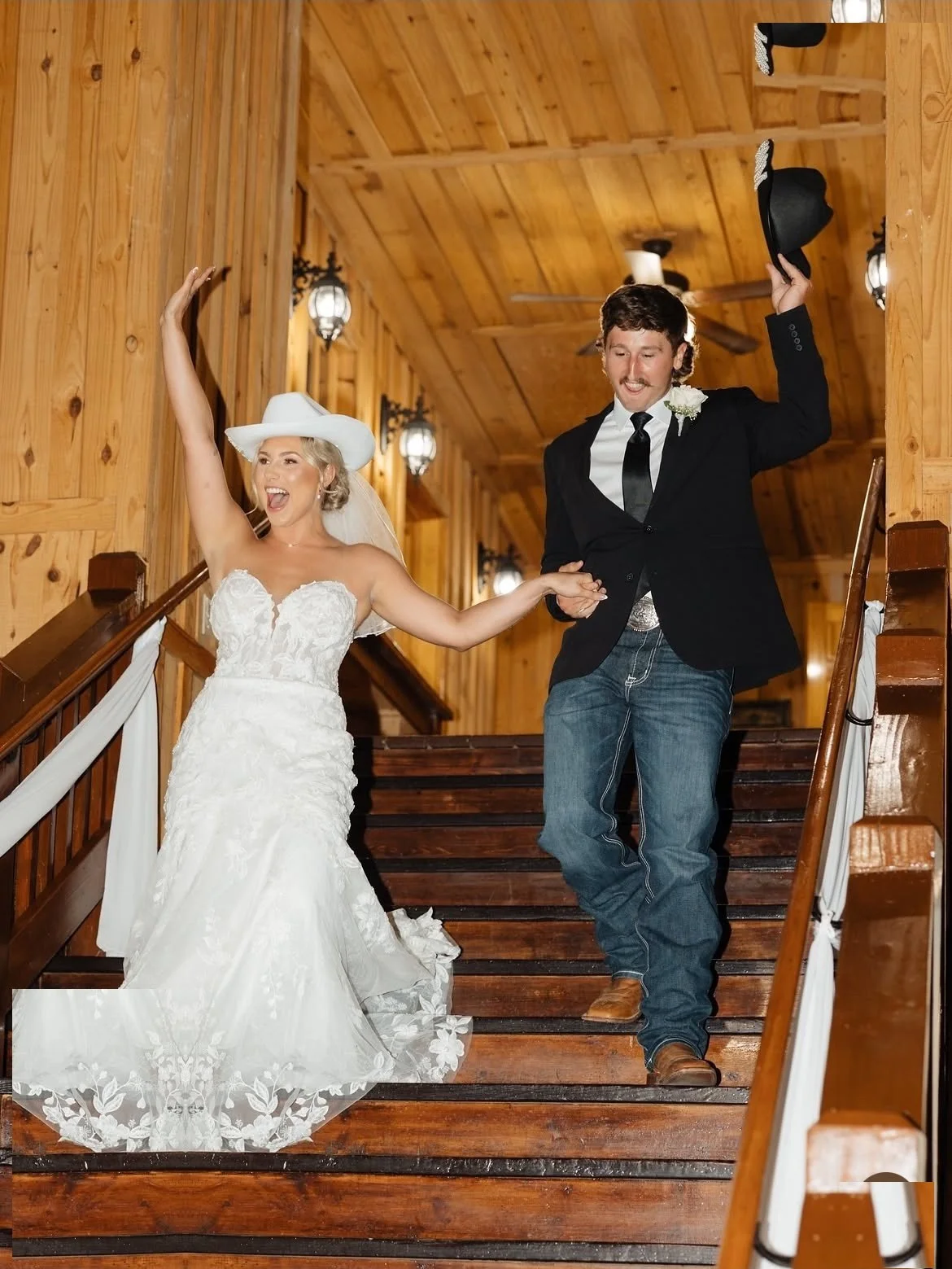 10-rayleigh-mason-the-springs-wedding-couple-stairs-cowboy-hats.jpg