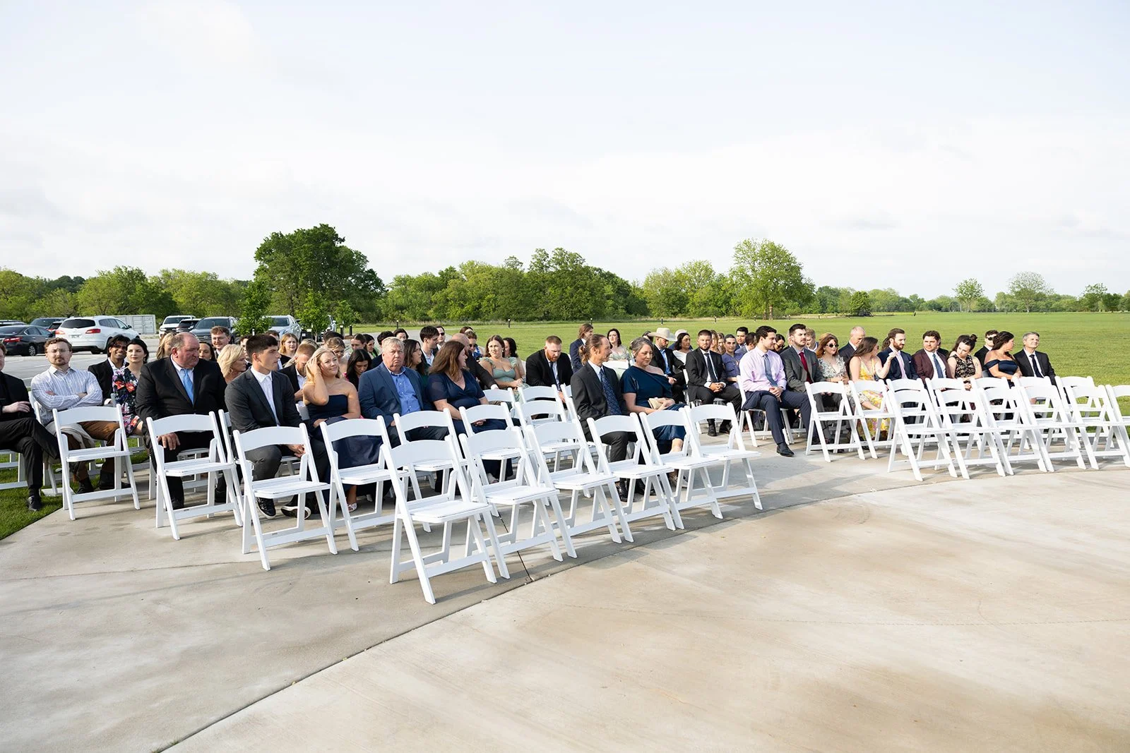 the ceremony in full, rows of guests under a heavy grey sky ·