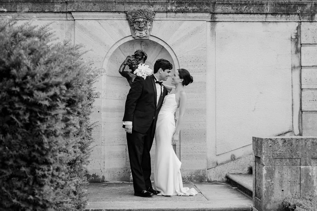 Black and white portrait of the couple kissing in a stone alcove at Philbrook Museum
