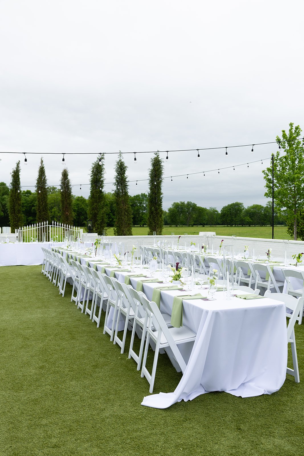 the outdoor reception tables on the lawn, set and waiting under dark skies and string lights · source: Cocktail Hour, cocktail_05