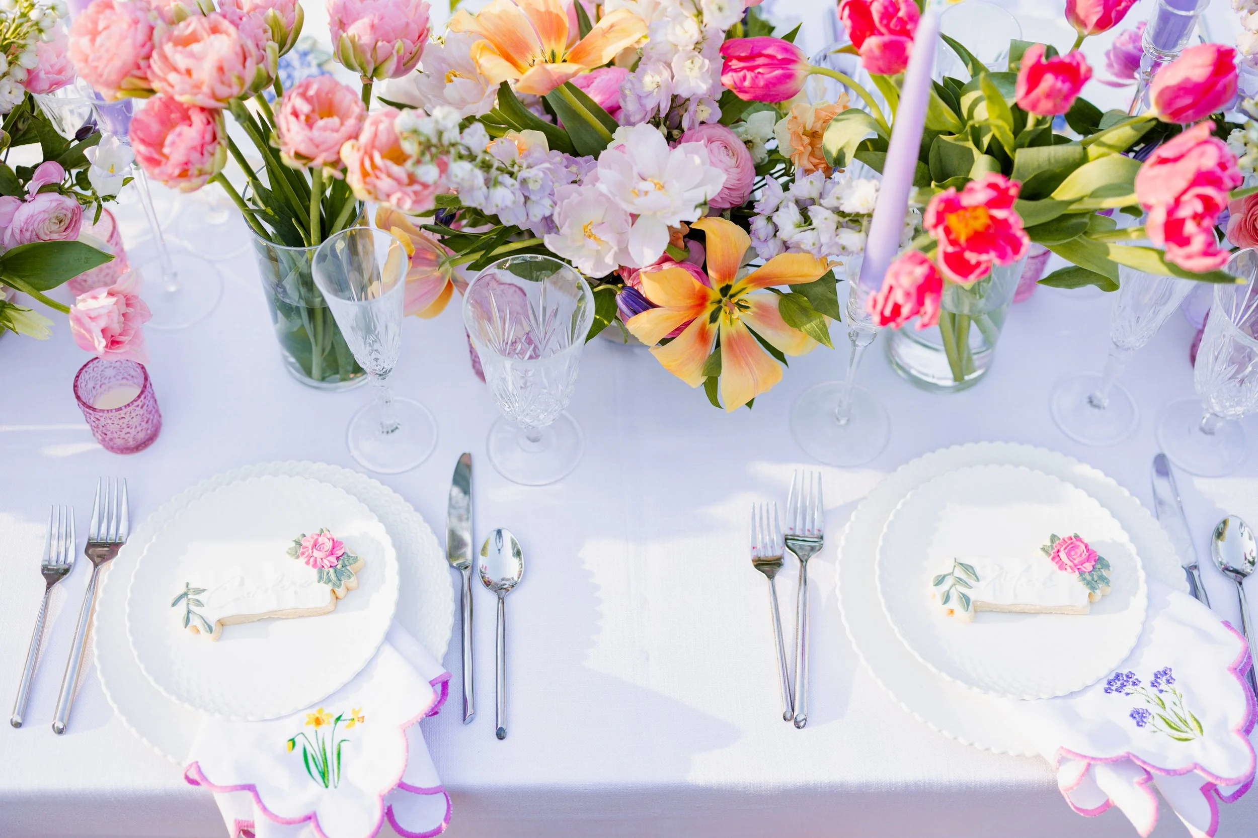 pastel centerpiece on wedding table with custom cookies as place cards, embroidered napkins