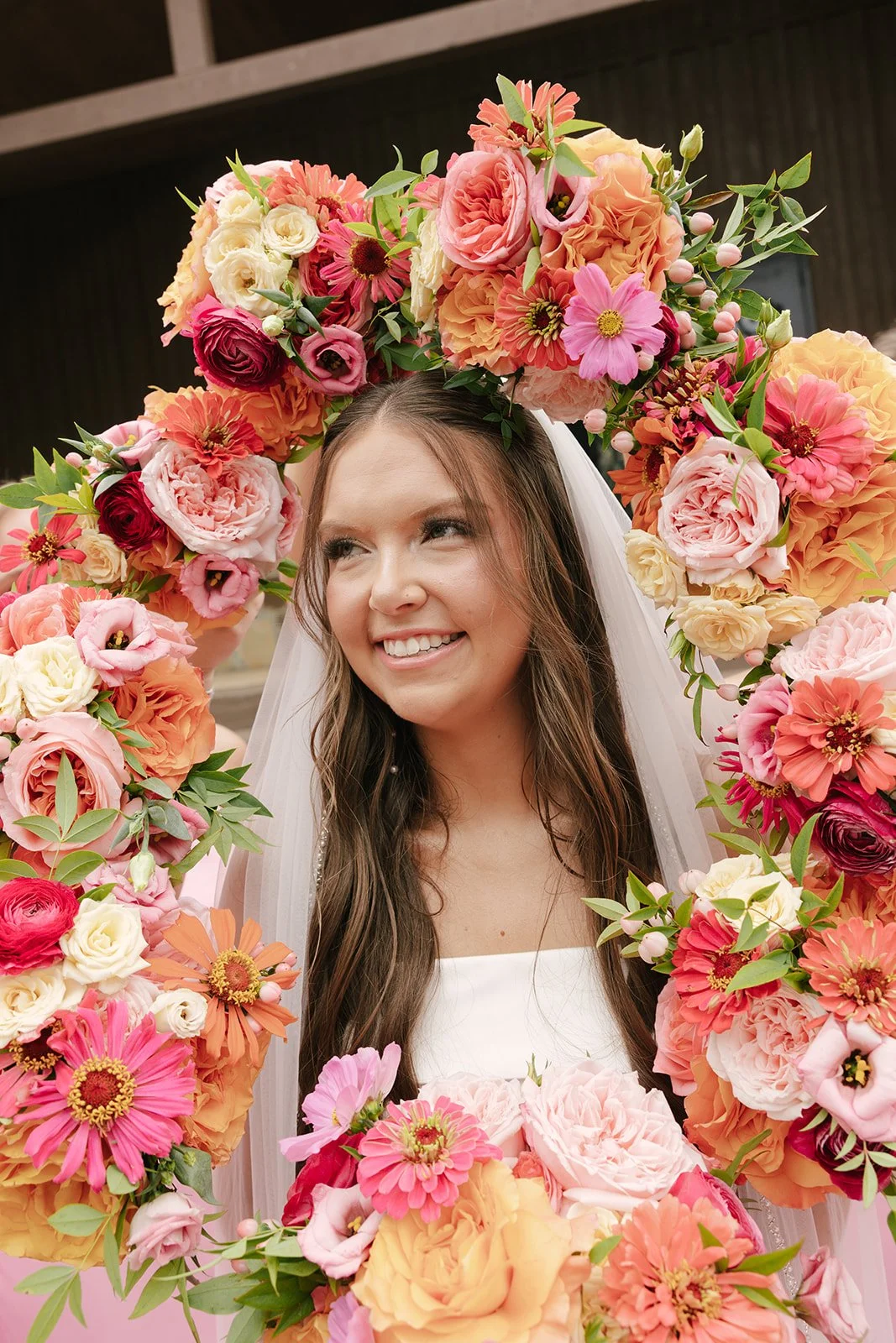 bride with beautiful bouquets in spring colors of pink around her face
