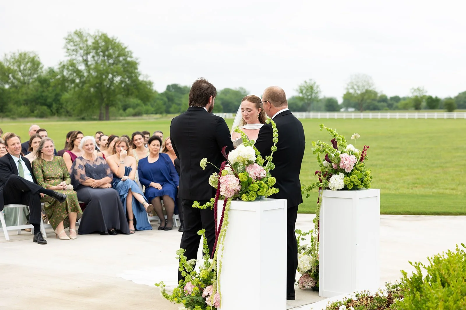 Elizabeth & Ryan at the altar, seen from behind their guests · source: Ceremony, ceremony_18