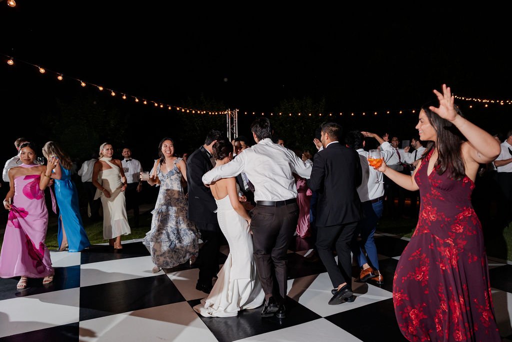 Bride and guests dancing under string lights at a Philbrook garden reception
