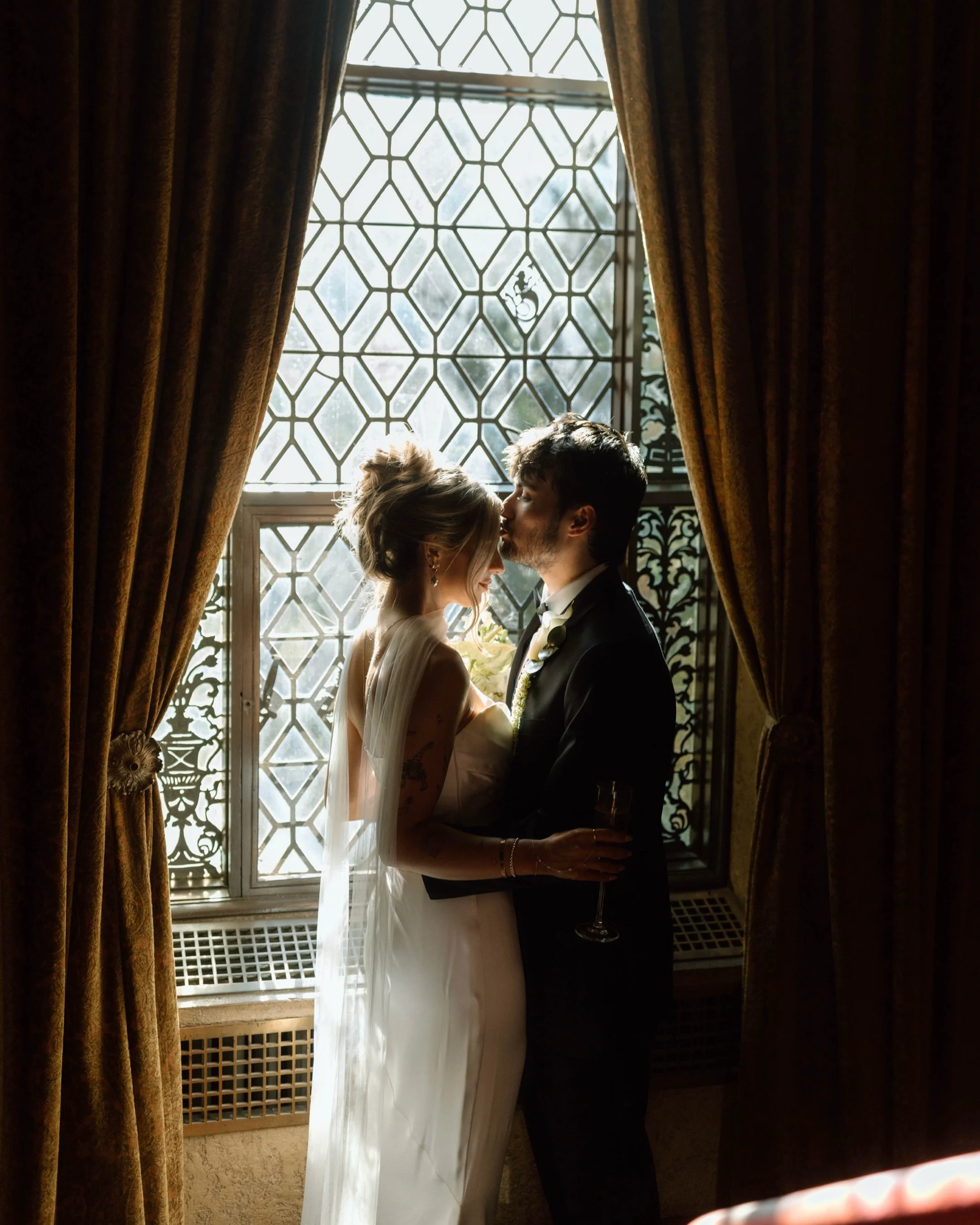 bride and groom in front of window