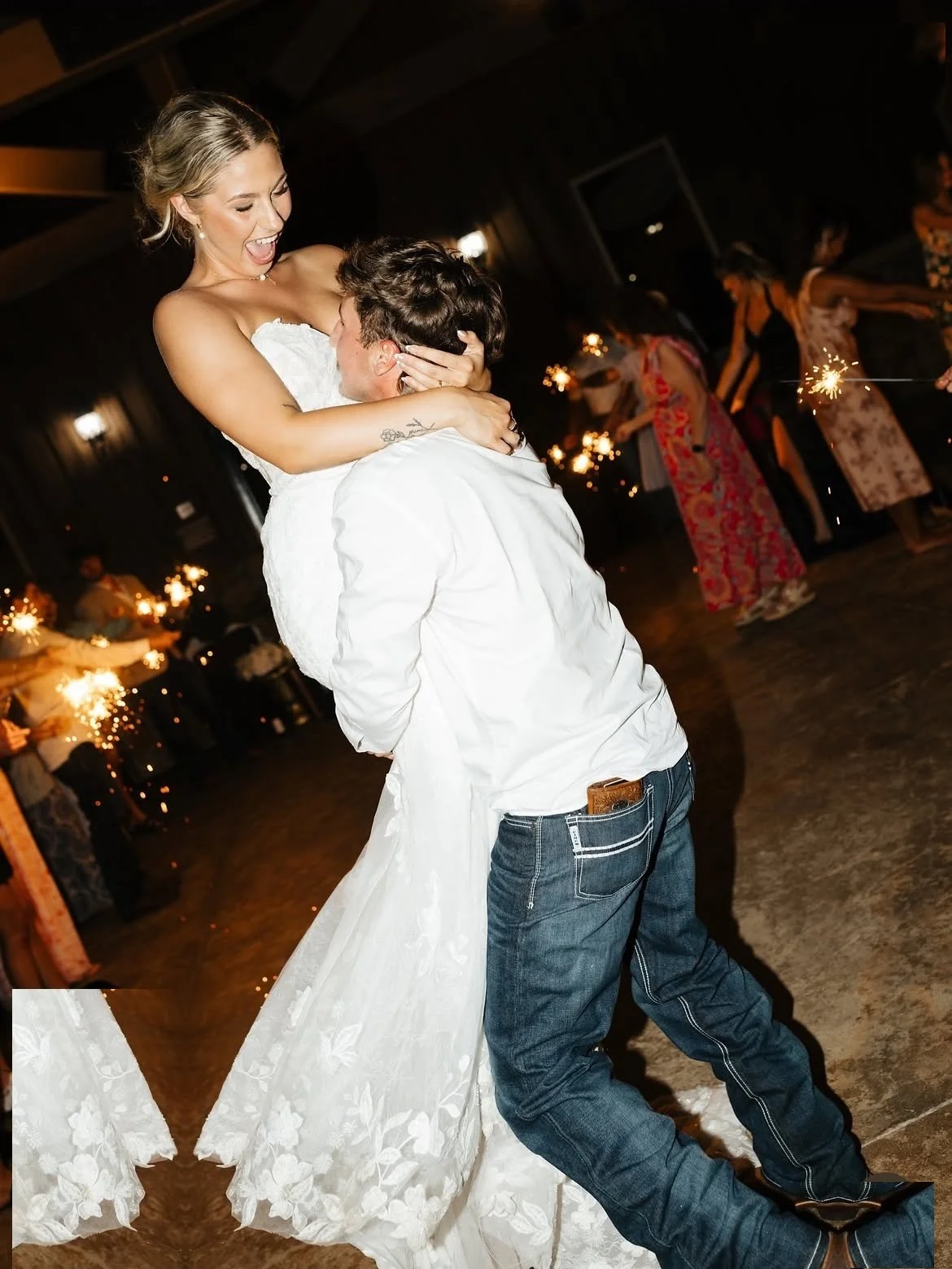 Groom lifting his bride during a sparkler send-off