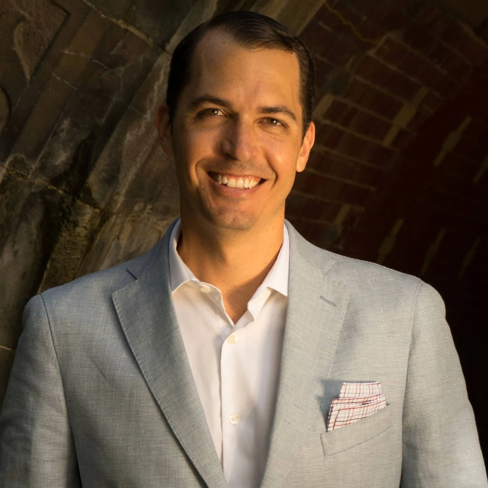 professional phot of Daniel Caffarel in a grey suit, smiling.