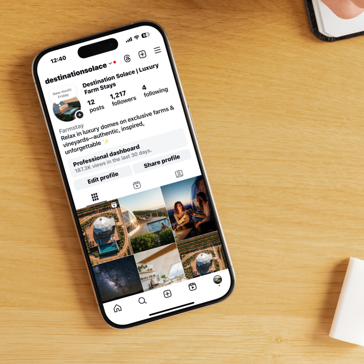 An iPhone displaying an Instagram profile with various travel and landscape photos, placed on an orange background.