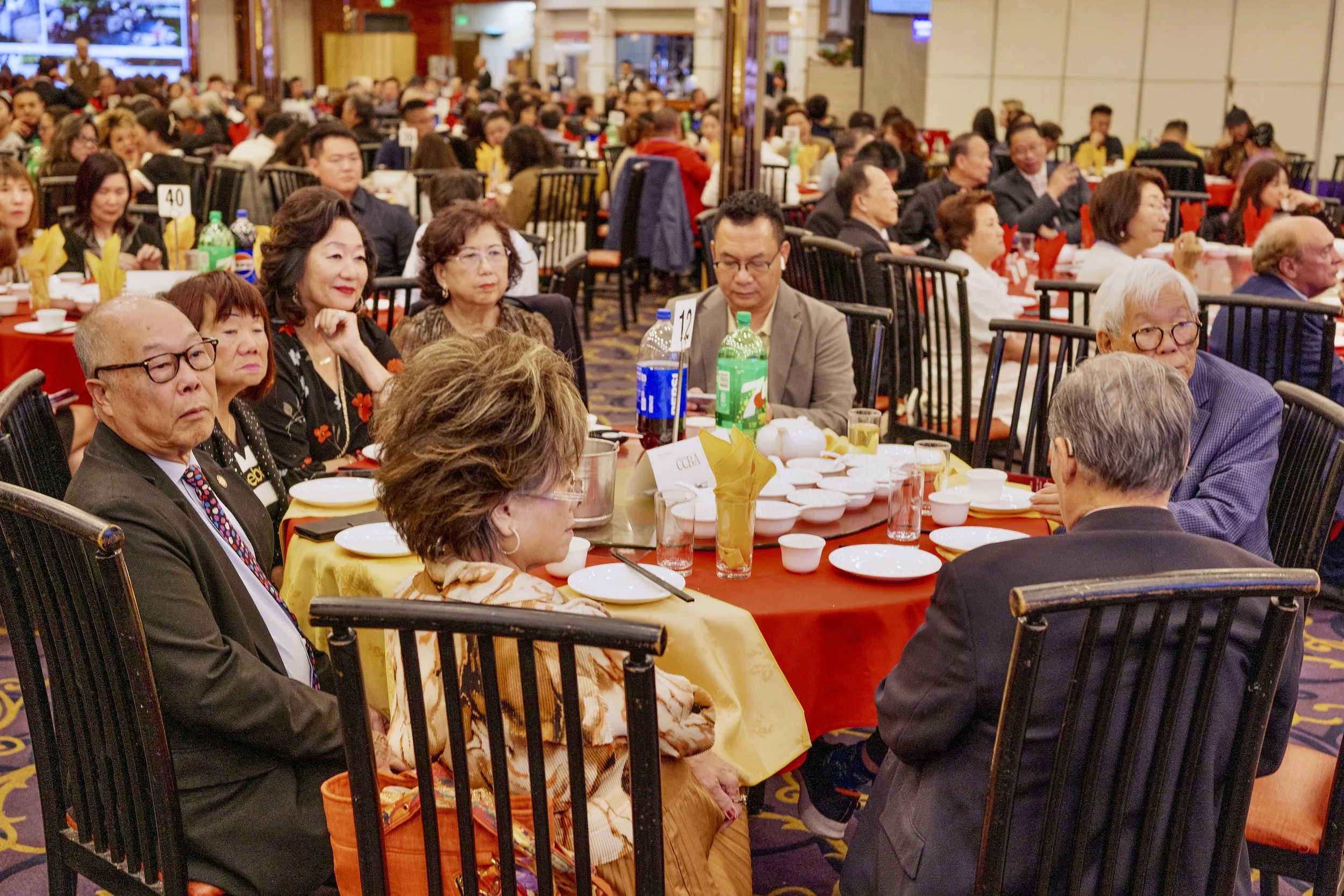 People seated around a large table at a formal event or banquet in a decorated indoor venue.