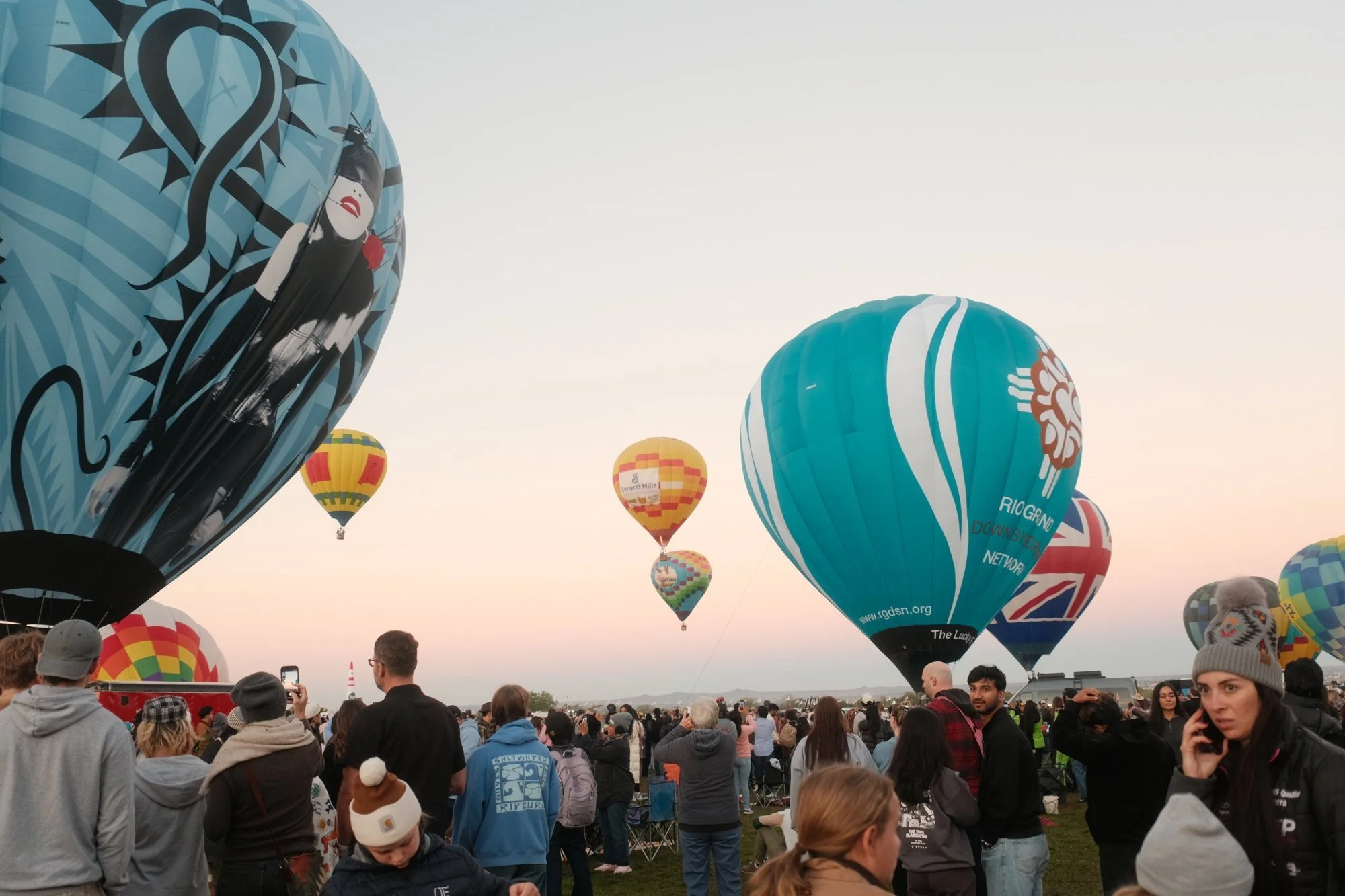 A crowd on the field in warm sunrise light