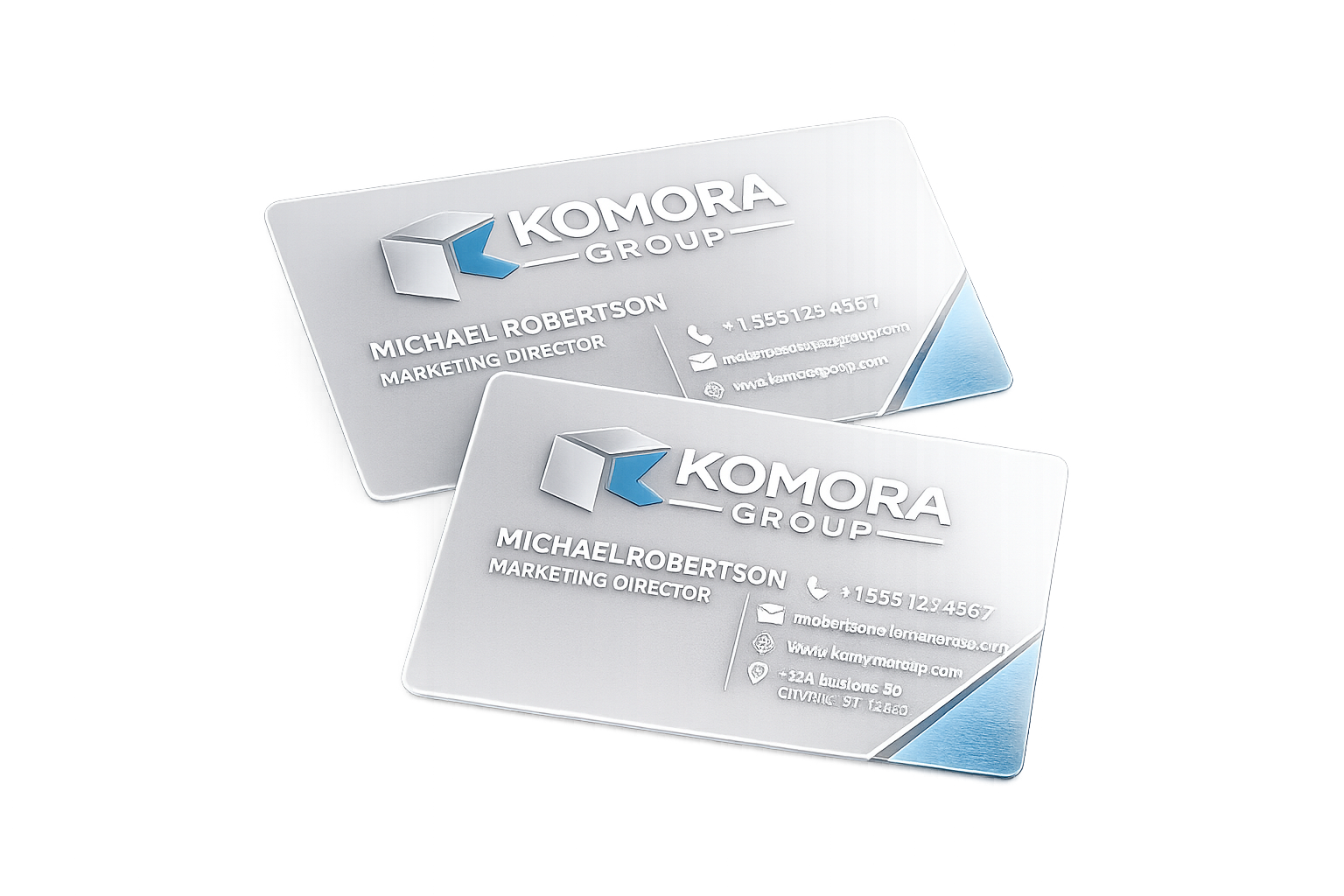 Two polished business cards for Komora Group with a logo and contact information, featuring a metallic silver background with blue accents.