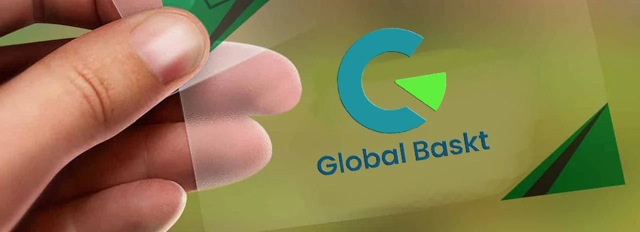 Close-up of a hand peeling back a sticker with the logo of Global Basket, which features a blue and green pie chart section and the text 'Global Basket' on a yellowish background.