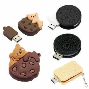 Collection of USB flash drives shaped like cookies and desserts, including two cookie-shaped drives with bear and dog designs, a black cookie design, and a cream-colored sandwich cookie design.