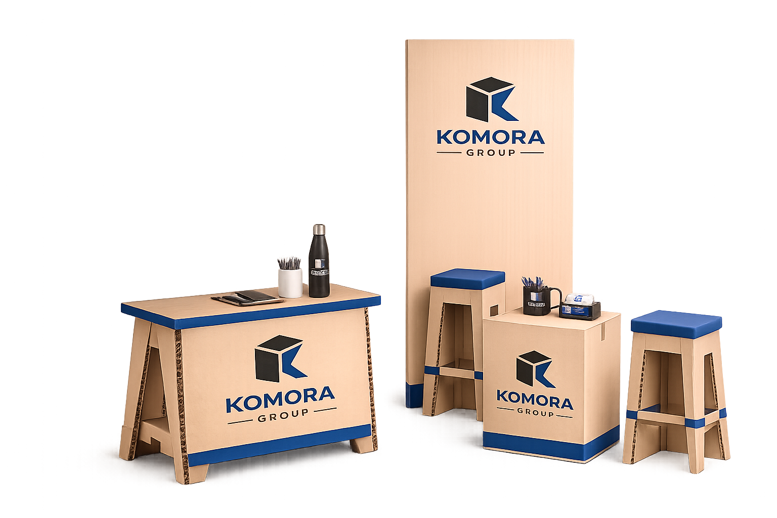 Display of wooden furniture with Komora Group logo, including a counter, small table, and stools, with office supplies on top.
