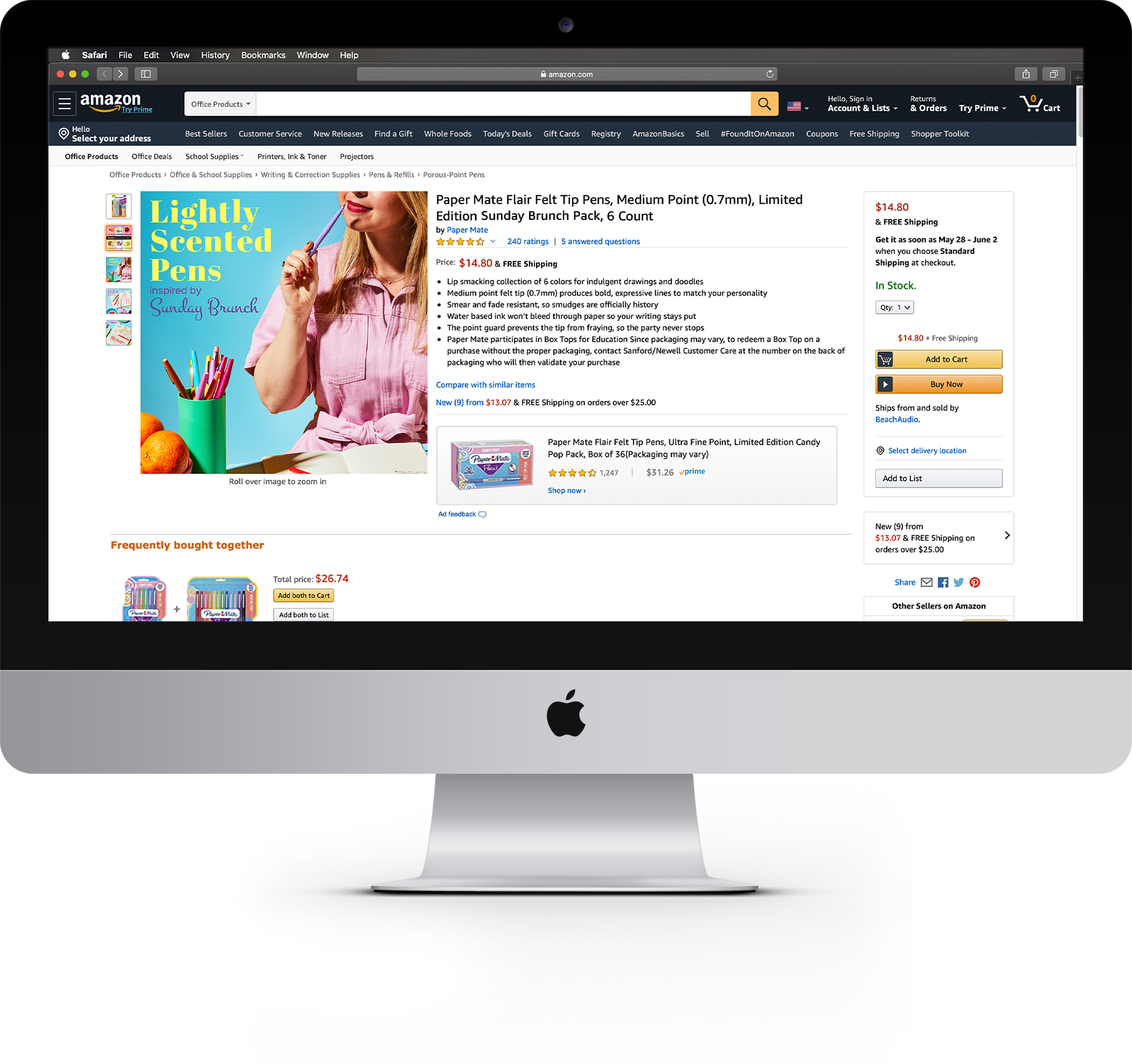 An iMac computer displaying an Amazon product page for lightly scented pens, featuring a woman in a pink shirt holding a purple pen against a blue background with colorful stationery.