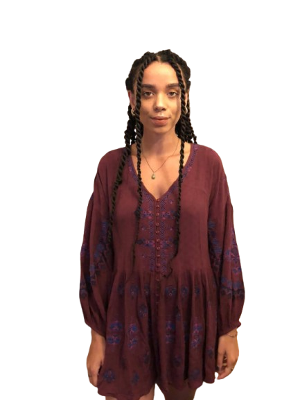 Person wearing a maroon dress with long sleeves and floral patterns