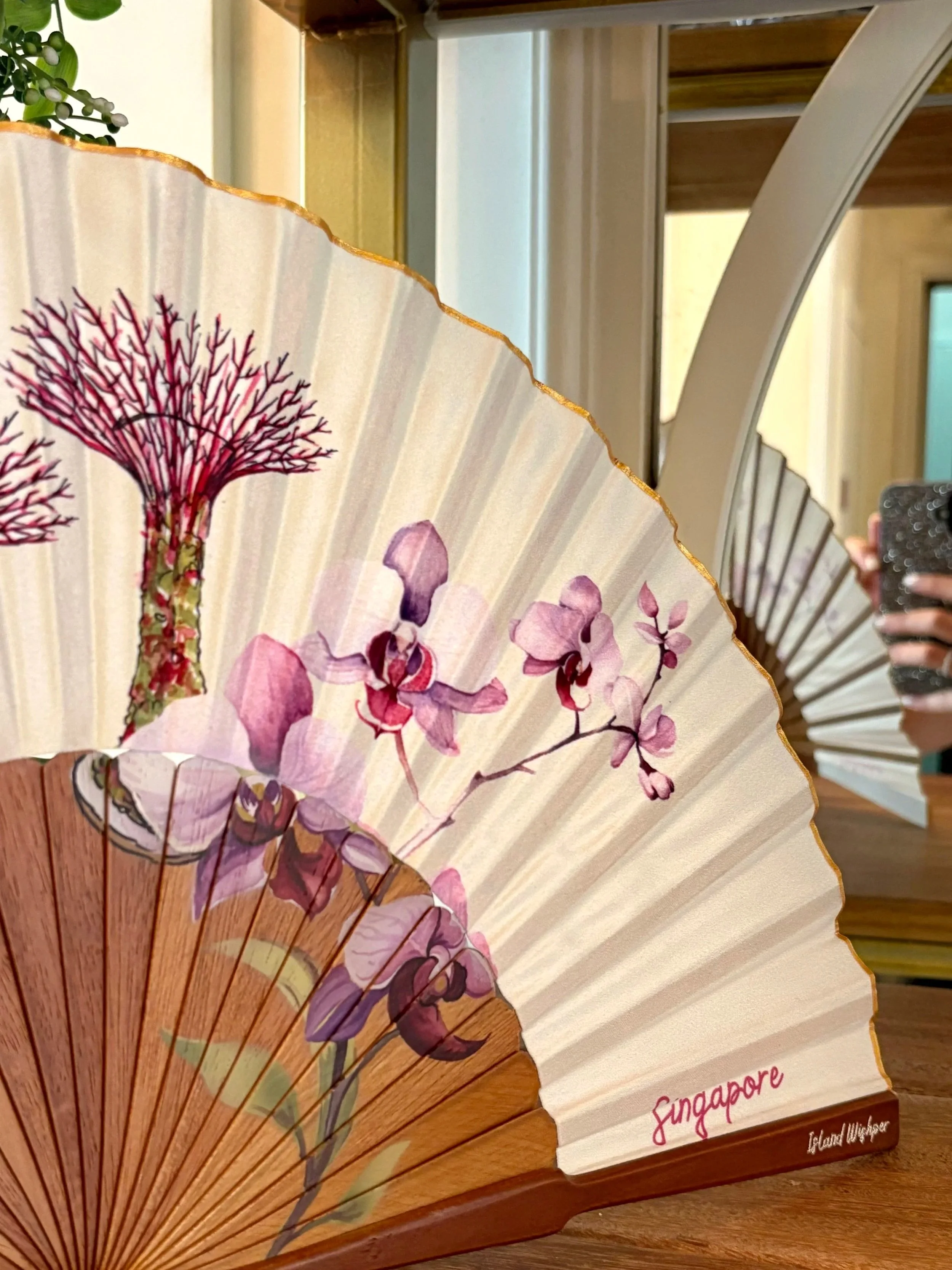 Abanico de lujo a medida de Island Whisper Atelier con diseño inspirado en Singapur, madera natural y acabado artesanal.