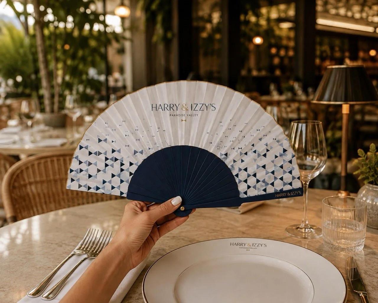 Bespoke hand fan created for Harry & Izzy's, combining branded detailing with an elegant design for hospitality and guest experience.