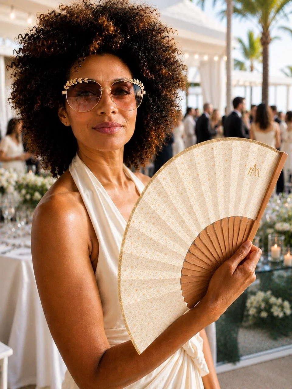Bespoke luxury hand fan by Island Whisper Atelier at an elegant brand event, featuring natural wood and a refined gold design.