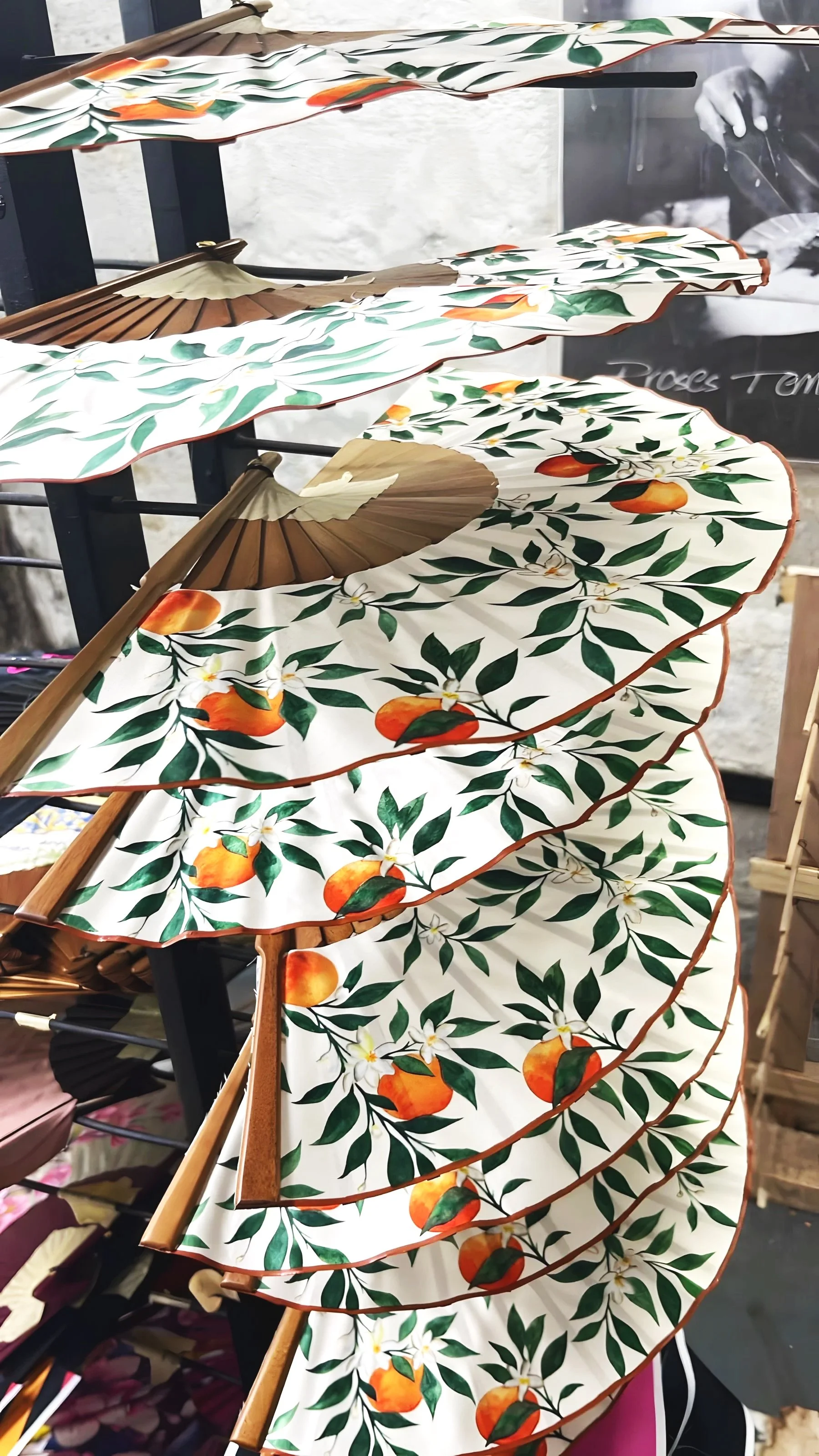 Bespoke luxury hand fans by Island Whisper Atelier in production for Thompson Seville, featuring orange tree artwork inspired by Seville, Spain.