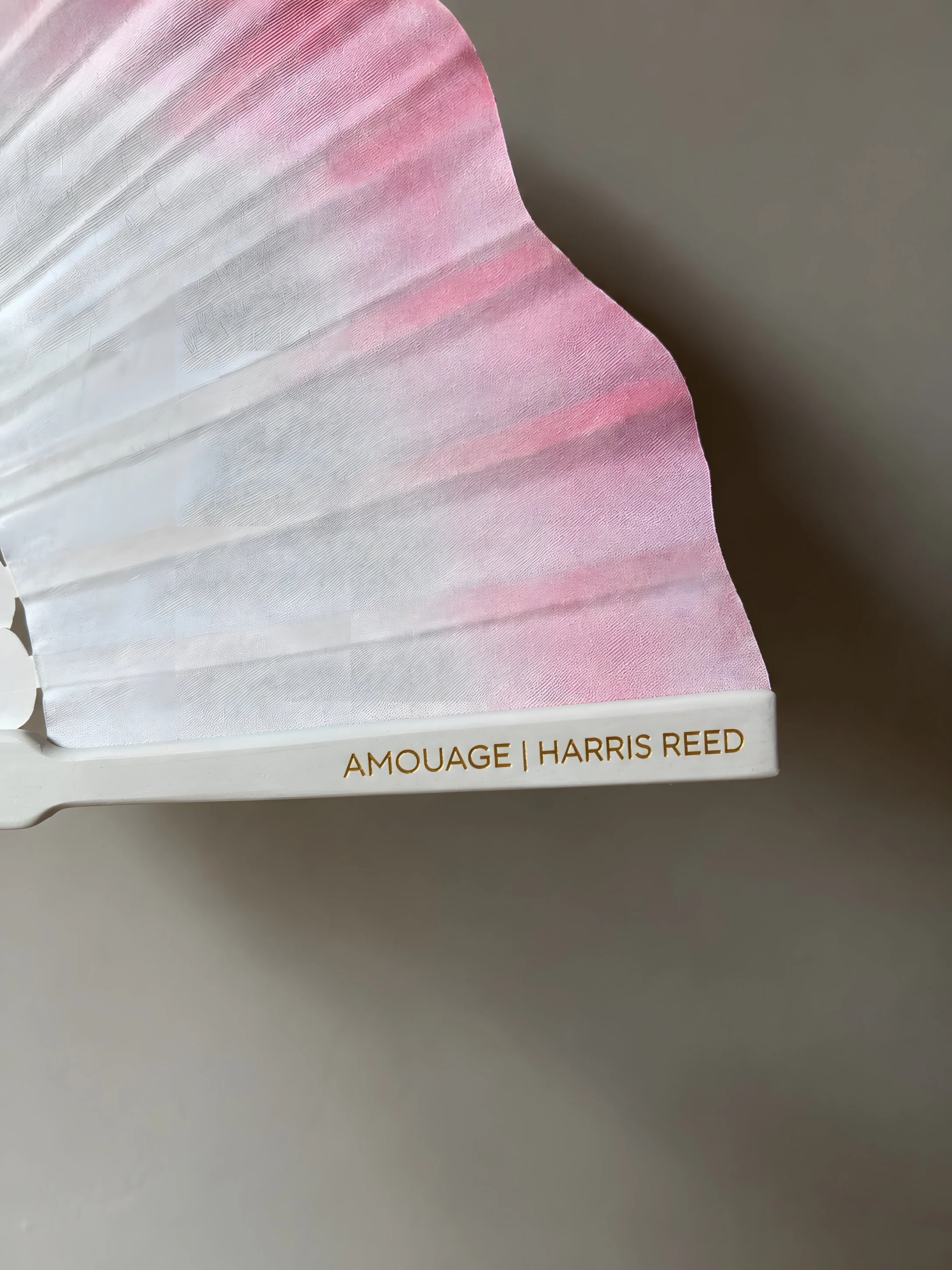 Detail of a custom hand fan created for Amouage x Harris Reed, featuring branded engraving on the outer stick. An example of how luxury identities can be integrated into bespoke pieces for events, collaborations and brand experiences.