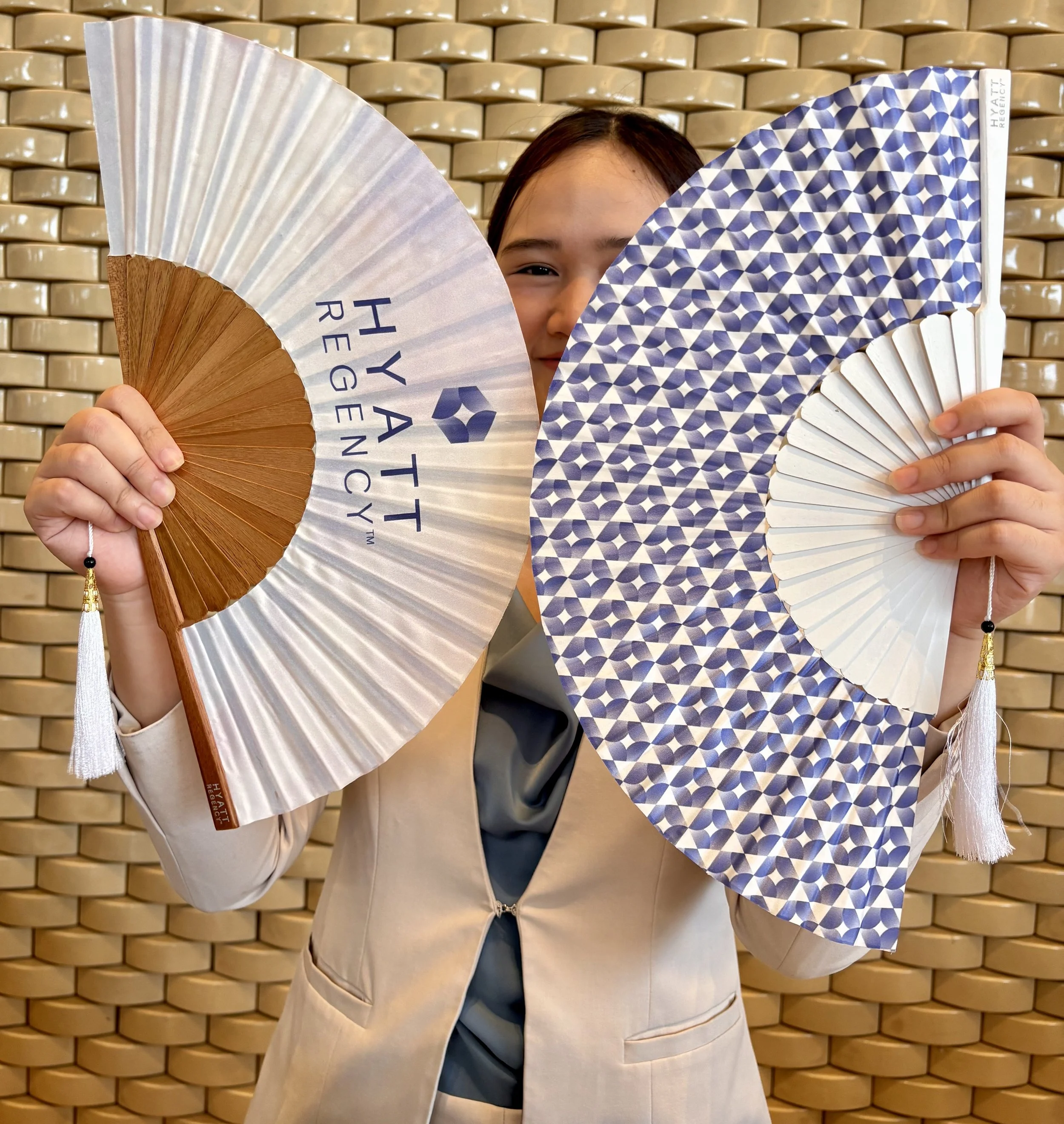 Luxury hotel guests holding bespoke handcrafted hand fans created by Island Whisper Atelier during a premium hospitality event.
