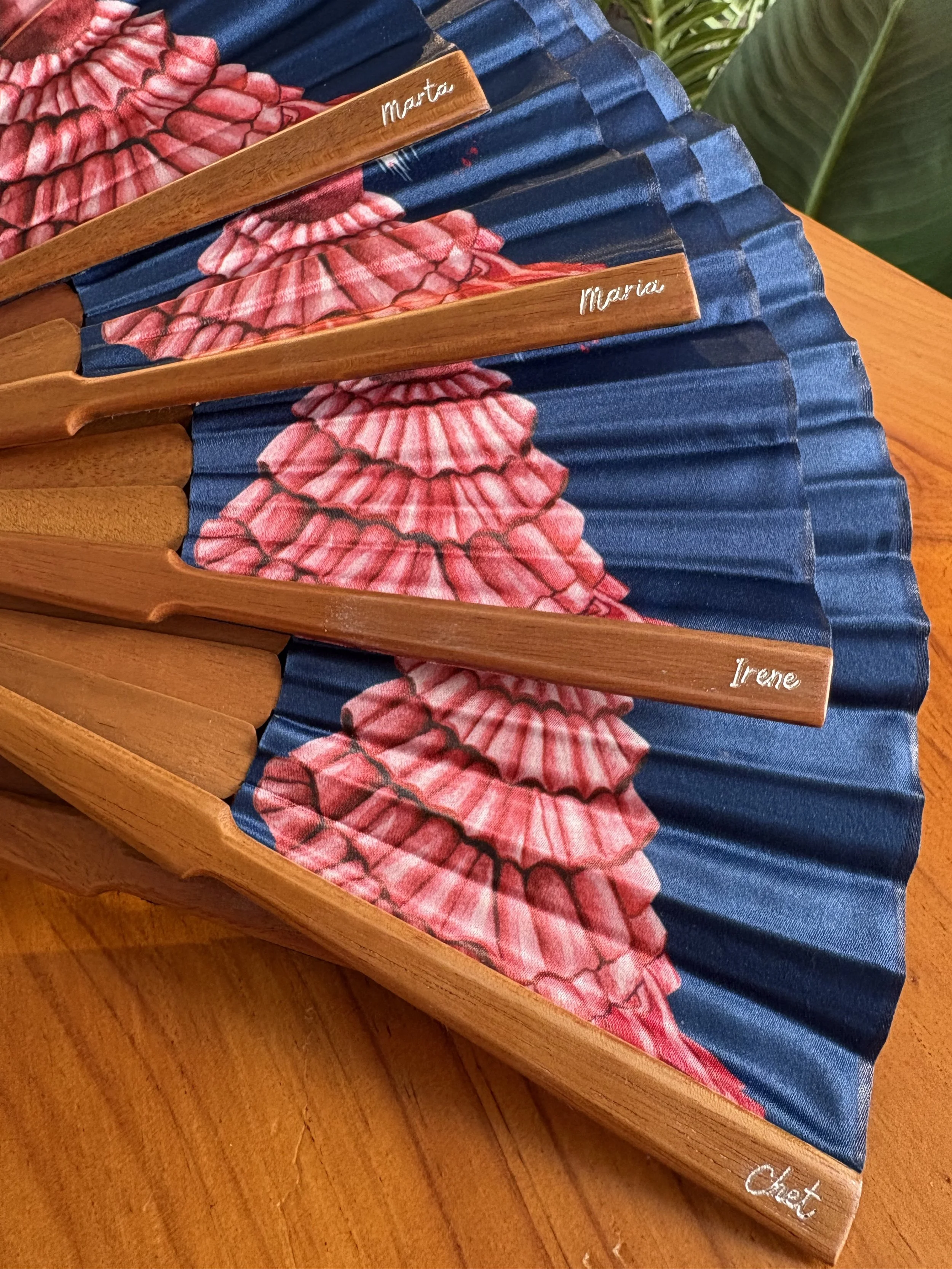 Abanicos de lujo a medida personalizados con nombres individuales de invitados grabados sobre varillas de madera natural.