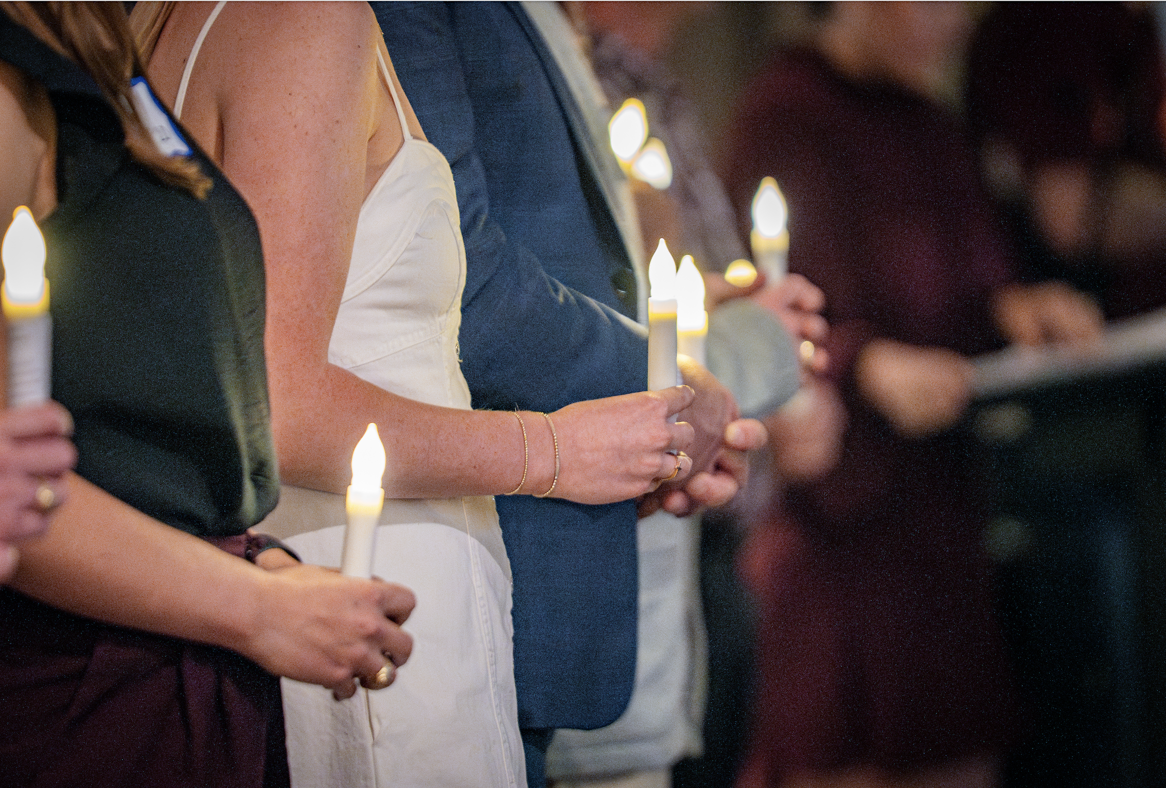 People holding lit candles in a candlelight vigil.