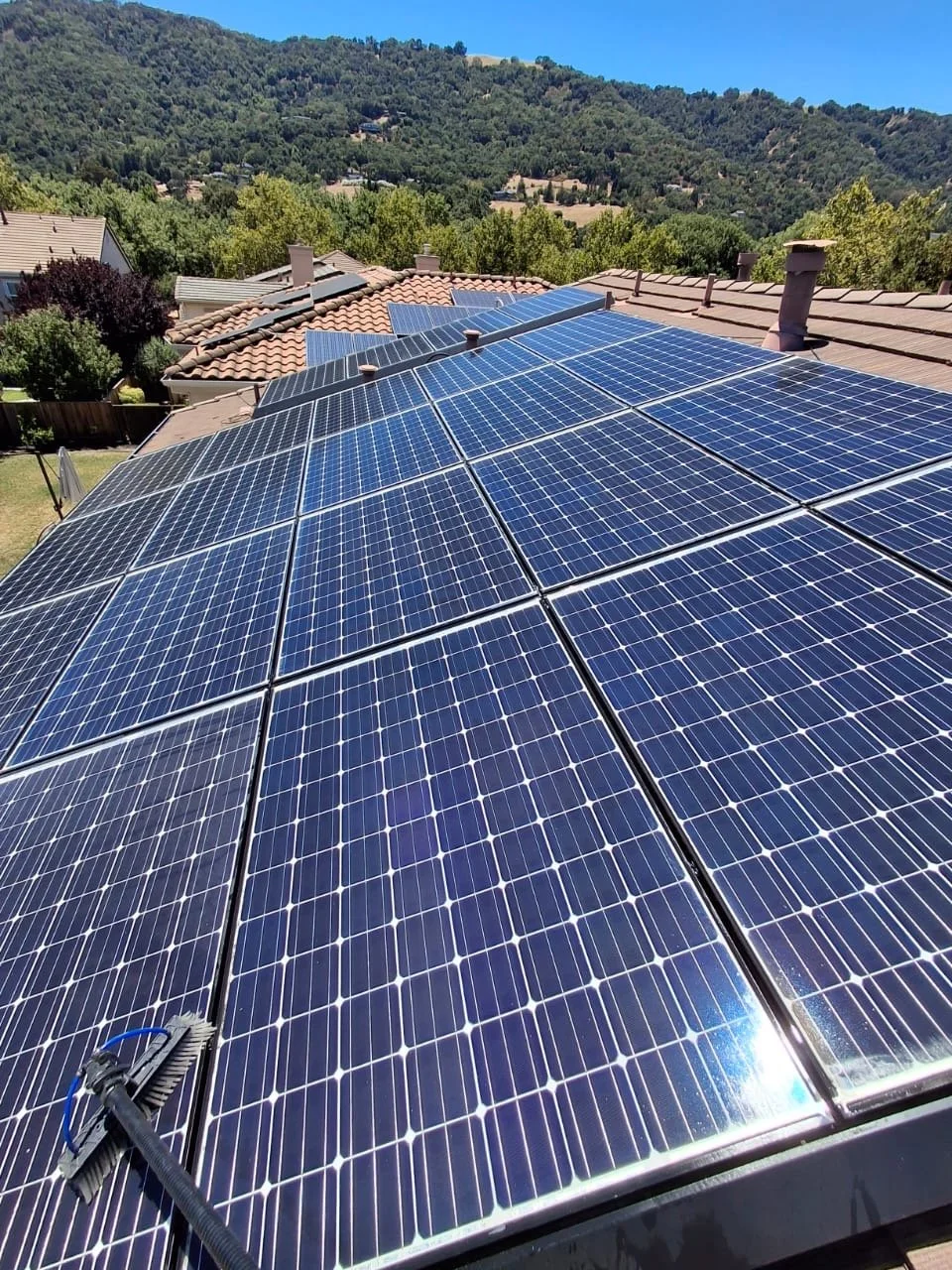Professional solar panel cleaning at a residential property in Pleasanton, CA, removing dirt and debris to help maximize energy efficiency.