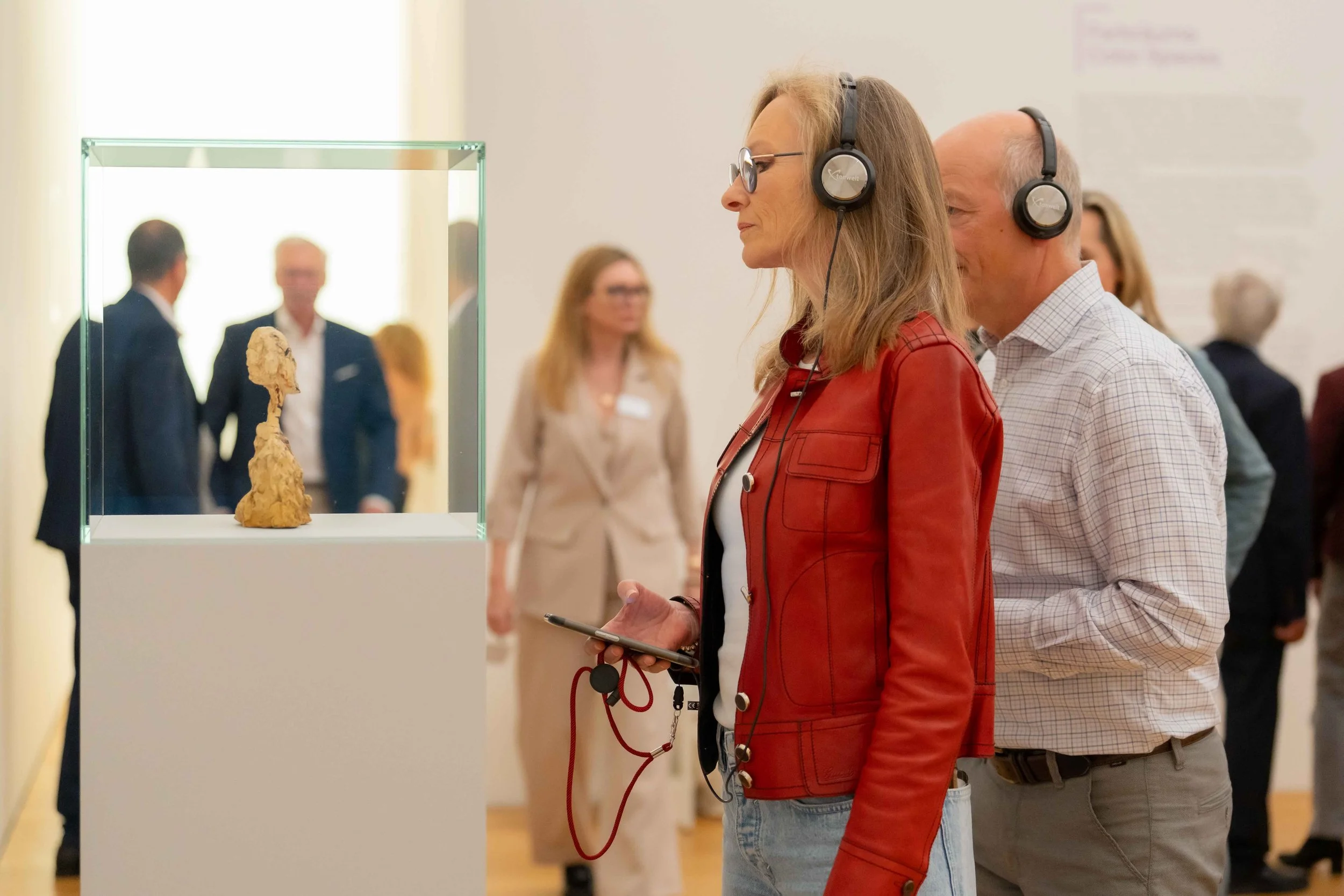 Eine Besucherin betrachtet eine Skulptur mit Mediaguide