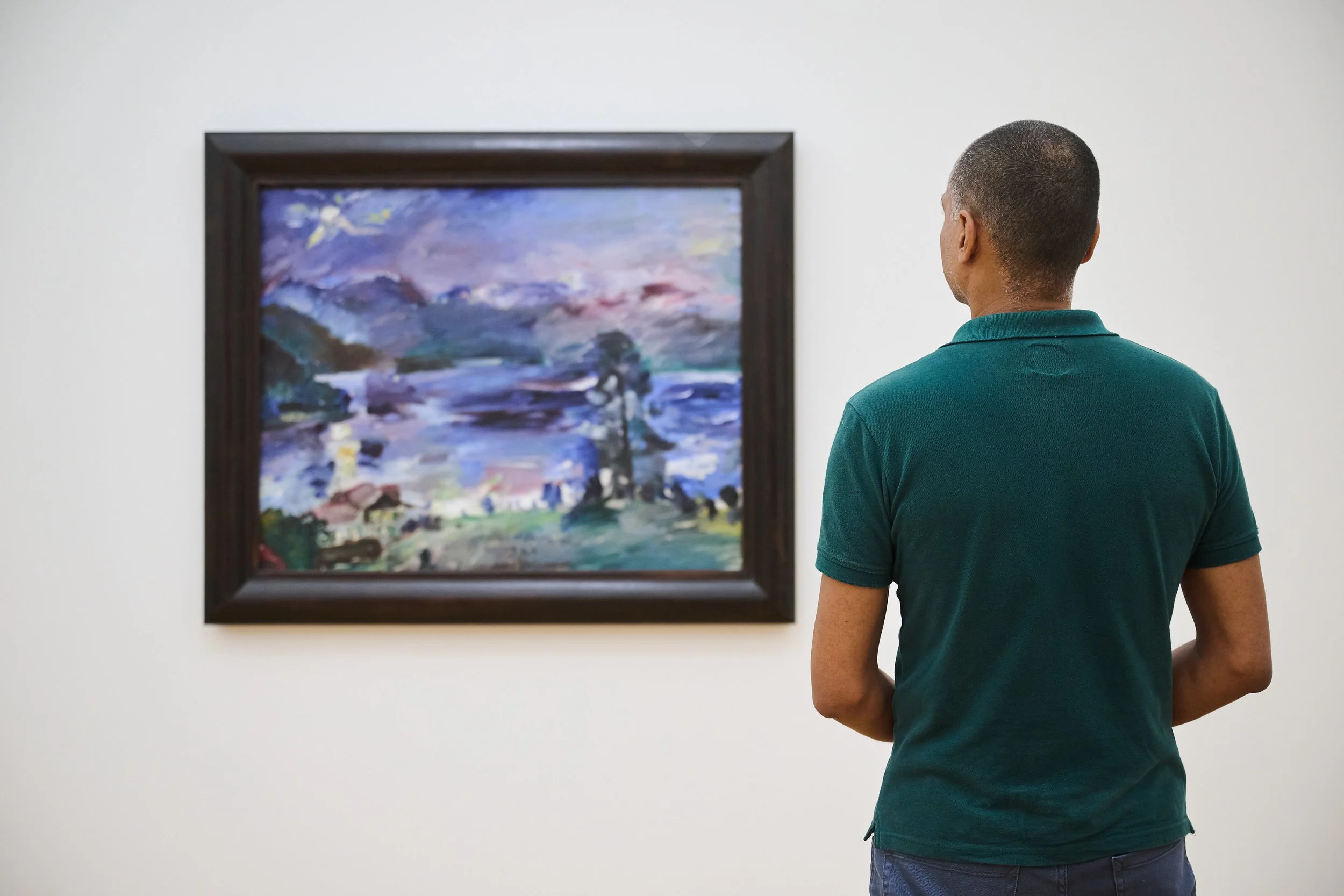 Ein Mann betrachtet ein Werk von Lovis Corinth