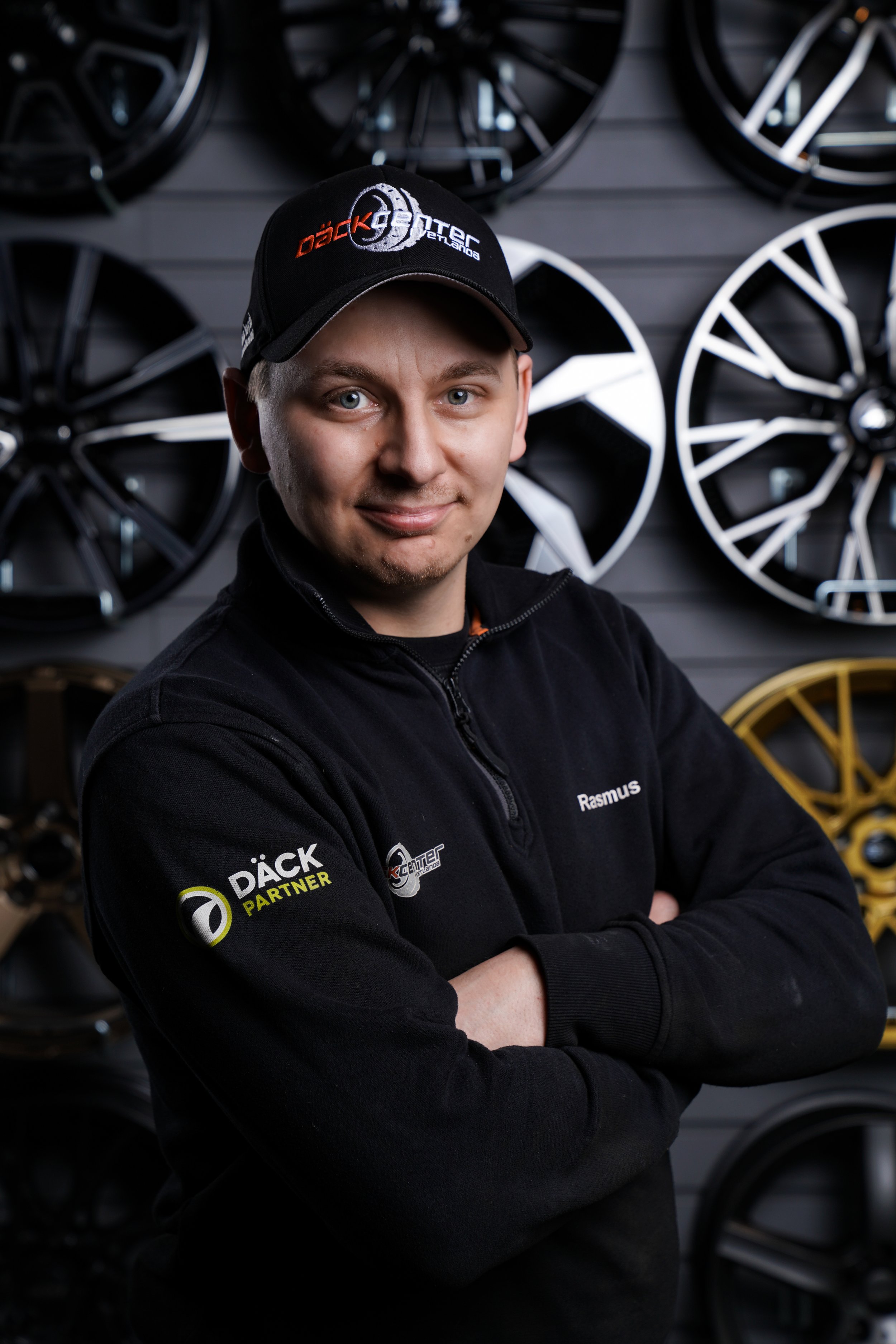 En man med glasögon, mörkt rufsigt hår, skägg och mustasch, klädd i en svart tröja, lutar sig lite åt sidan.