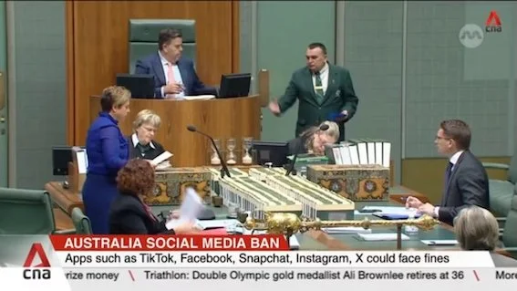 Australian parliament chamber with officials and members discussing, with a focus on social media ban and fines.
