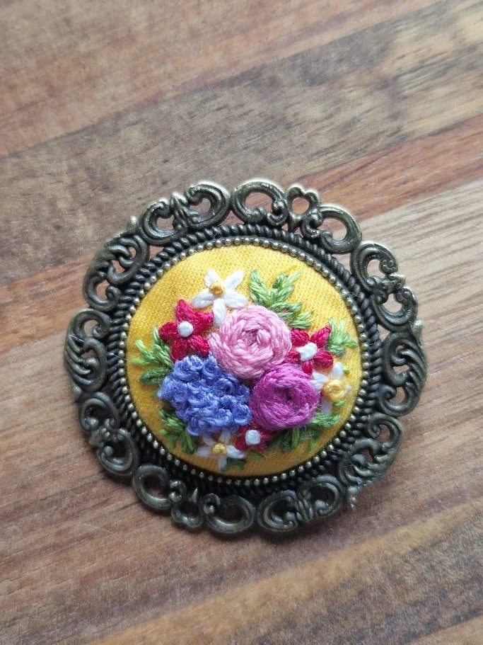 Hand-Embroidered Floral Brooch with Intricate Bronze Border