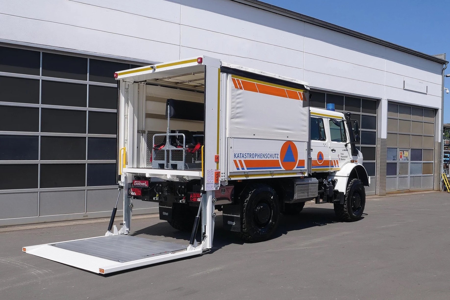 Gerätewagen Logistik Mercedes Benz Unimog für Katastrophenschutz Bremen aufgebaut von Göbel Fahrzeugbau, seitliche Heckansicht mit heruntergefahrenem Ladebordwand