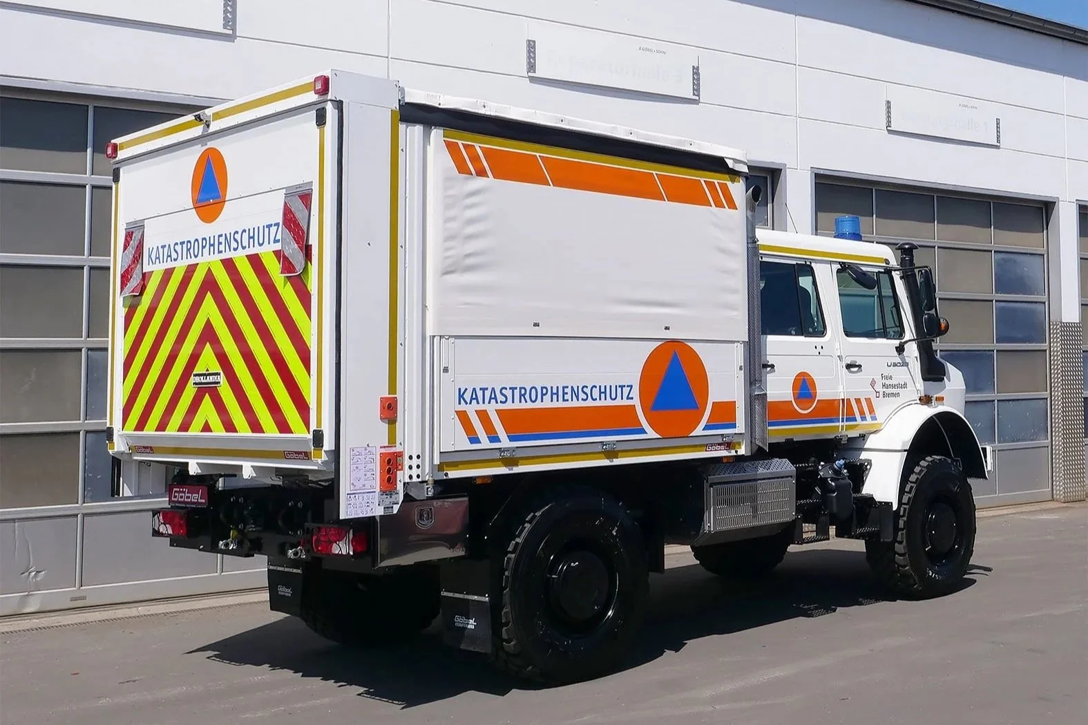 Gerätewagen Logistik Mercedes Benz Unimog für Katastrophenschutz Bremen aufgebaut von Göbel Fahrzeugbau, seitliche Heckansicht mit geschlossener Ladebordwand